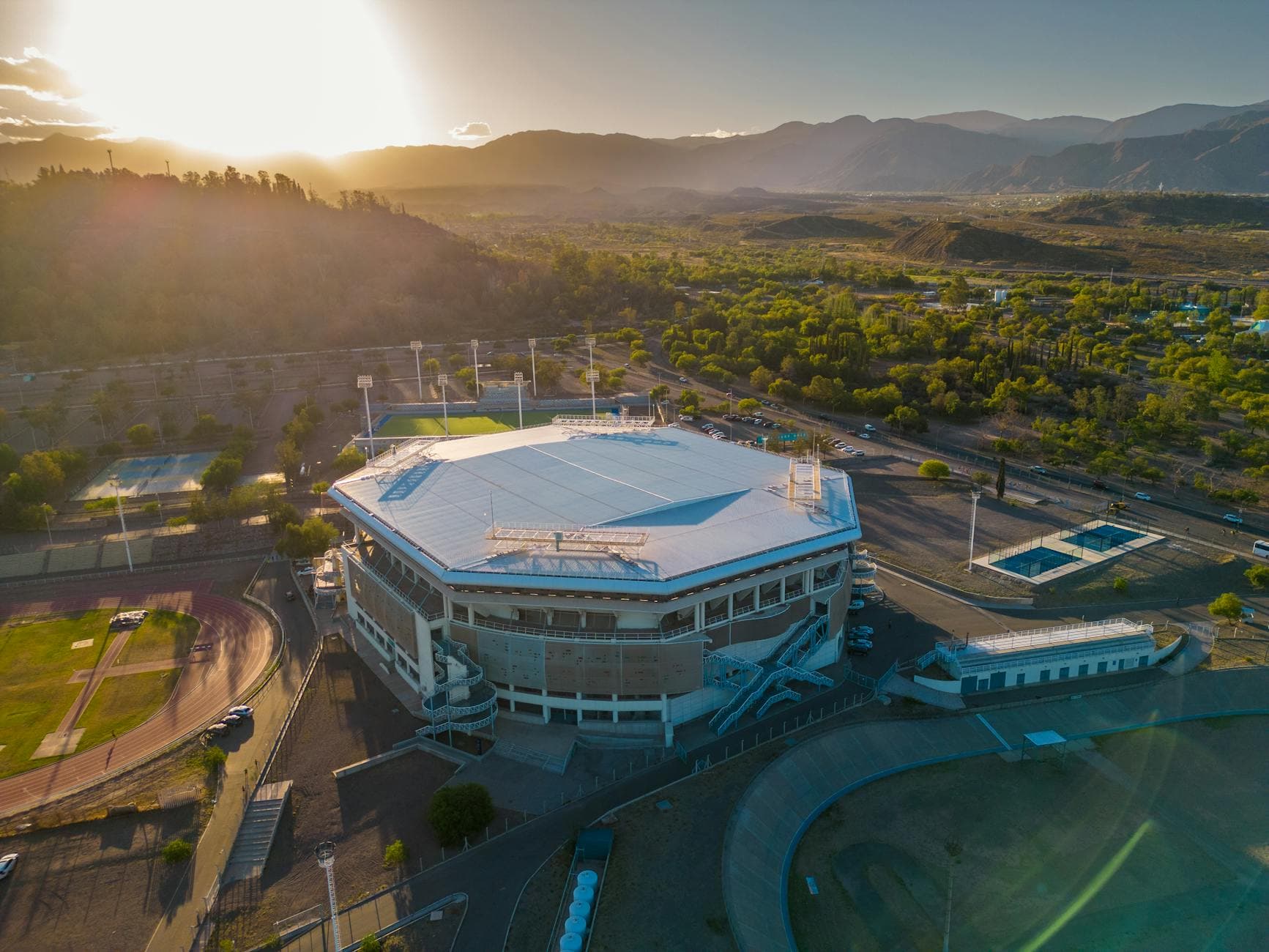 Stunning aerial shot of a stadium in Mendoza, Argentina at sunset with scenic mountain backdrop.