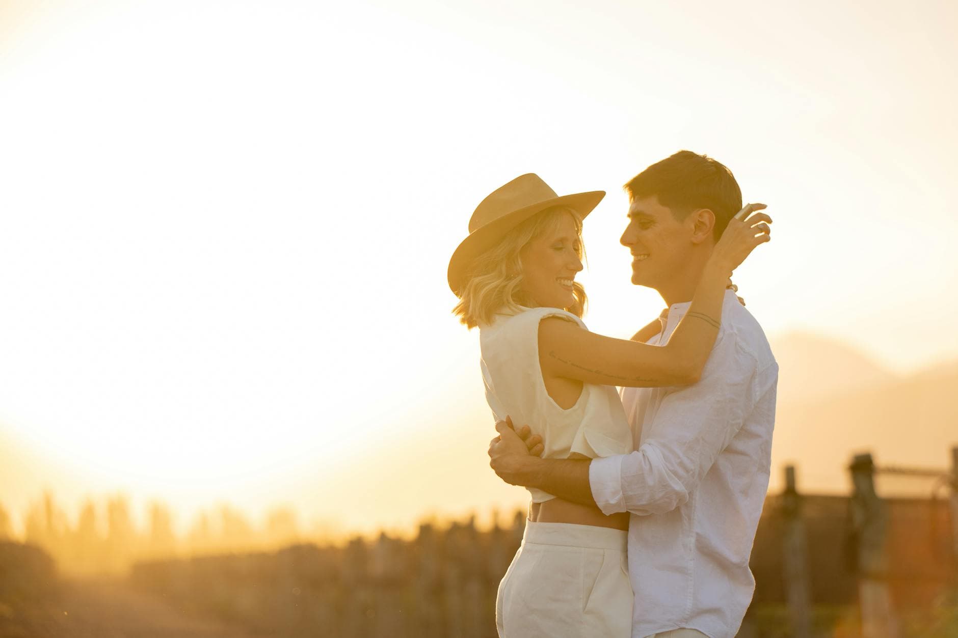 A couple lovingly embraces at sunset in Mendoza, Argentina, exuding warmth and romance.
