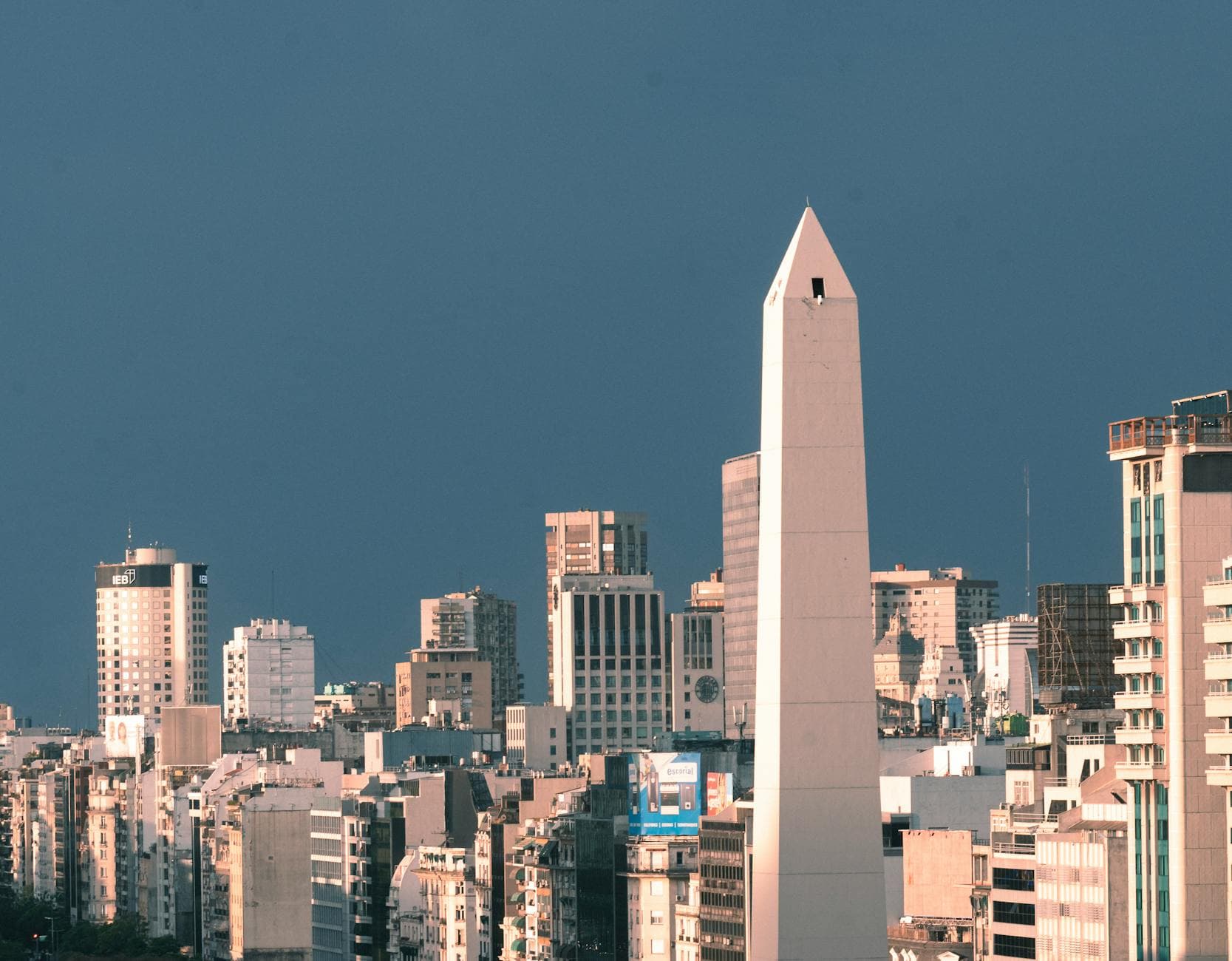 A stunning aerial view of Buenos Aires showcasing the iconic Obelisco surrounded by city skyscrapers.