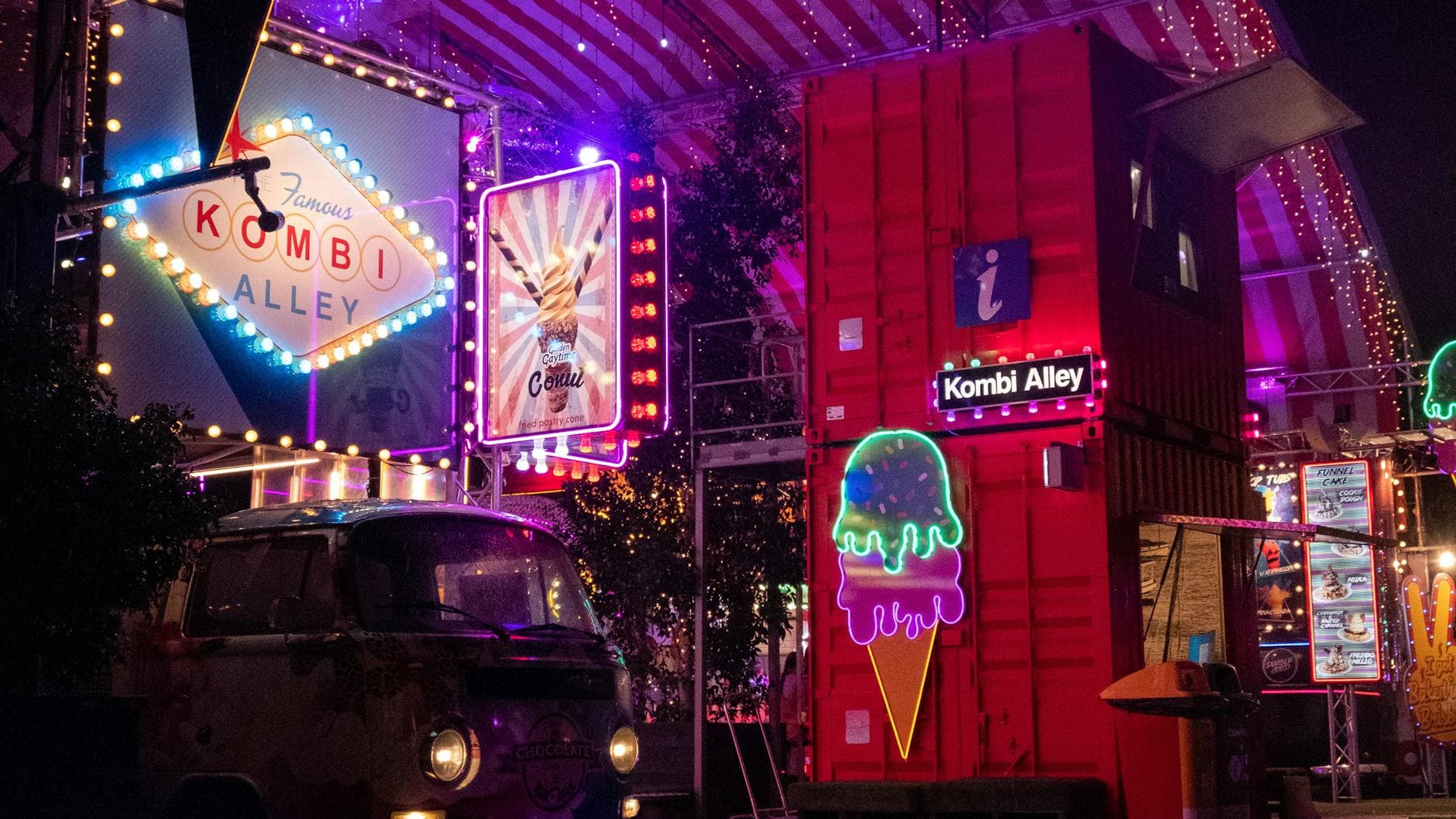Illuminated night scene capturing neon lights and vibrant atmosphere at Kombi Alley in Brisbane.
