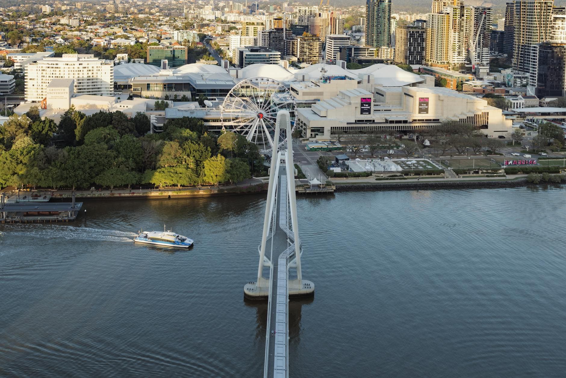 Stunning aerial view of the Brisbane Wheel with the city skyline in the background at sunset.