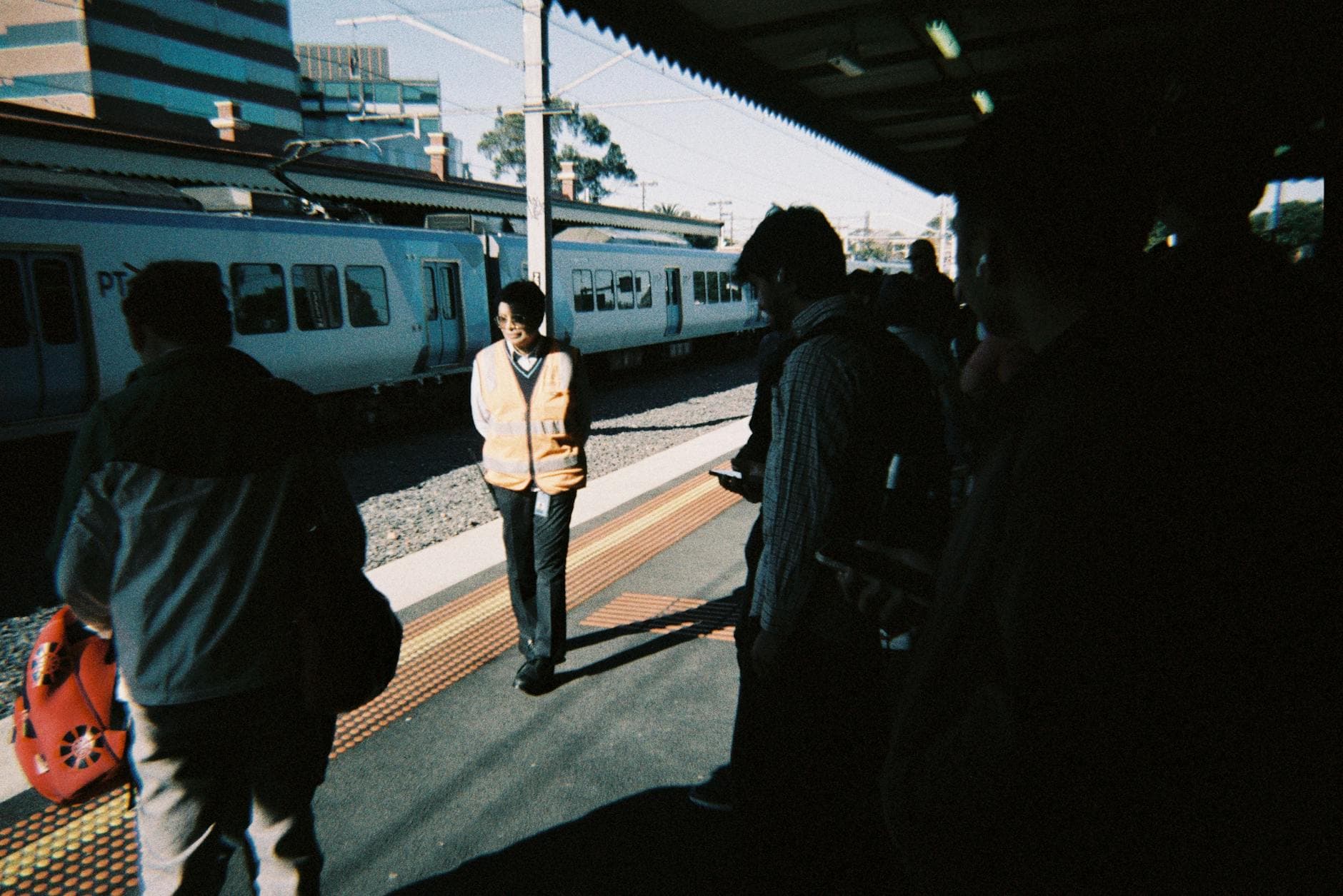 Commuters waiting for a metro train at a station in Melbourne, capturing morning bustle.
