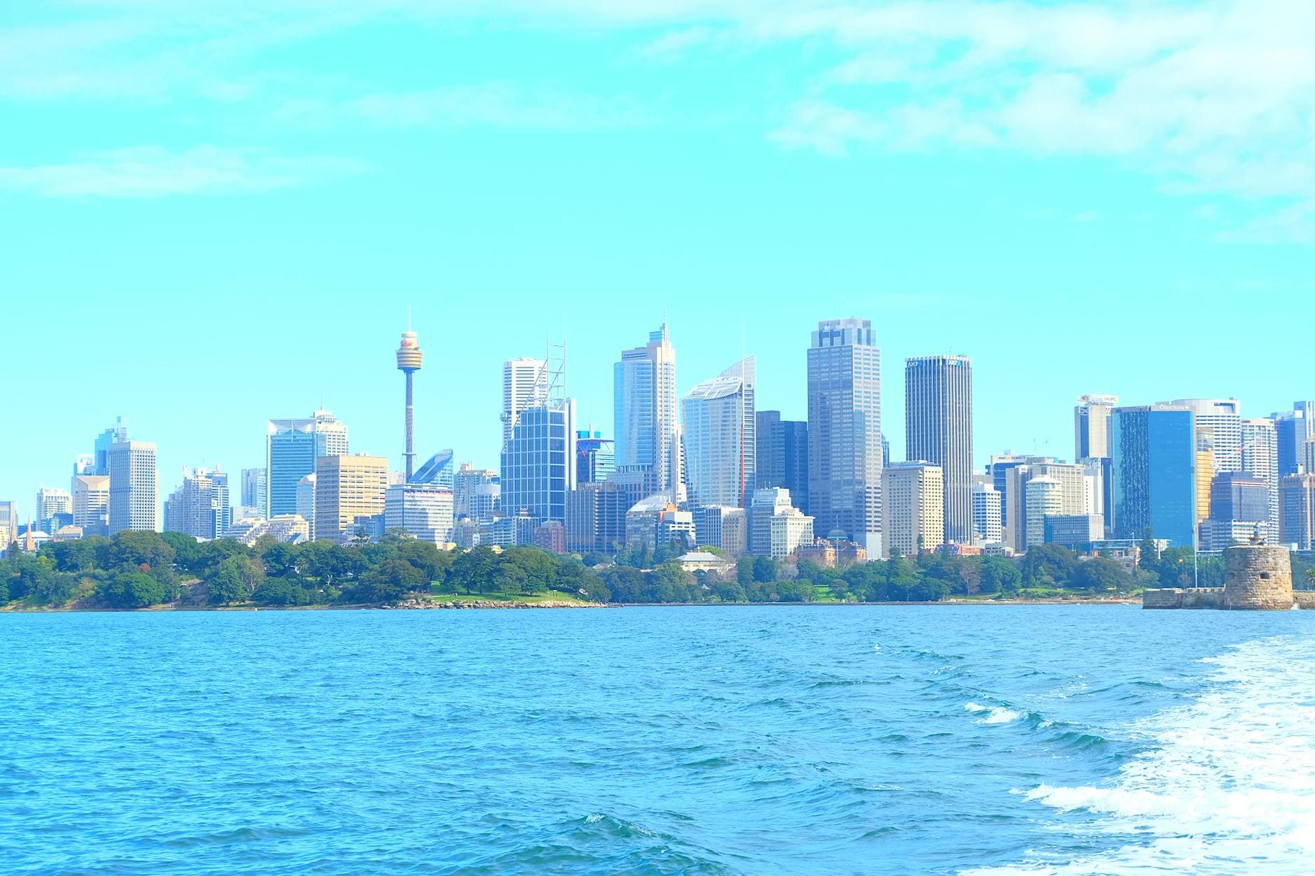 A stunning view of Sydney's skyline against a blue sky and waters.