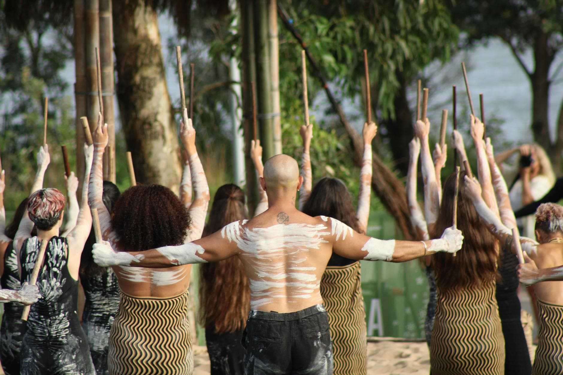 Group of dancers in traditional Aboriginal attire performing outdoors.