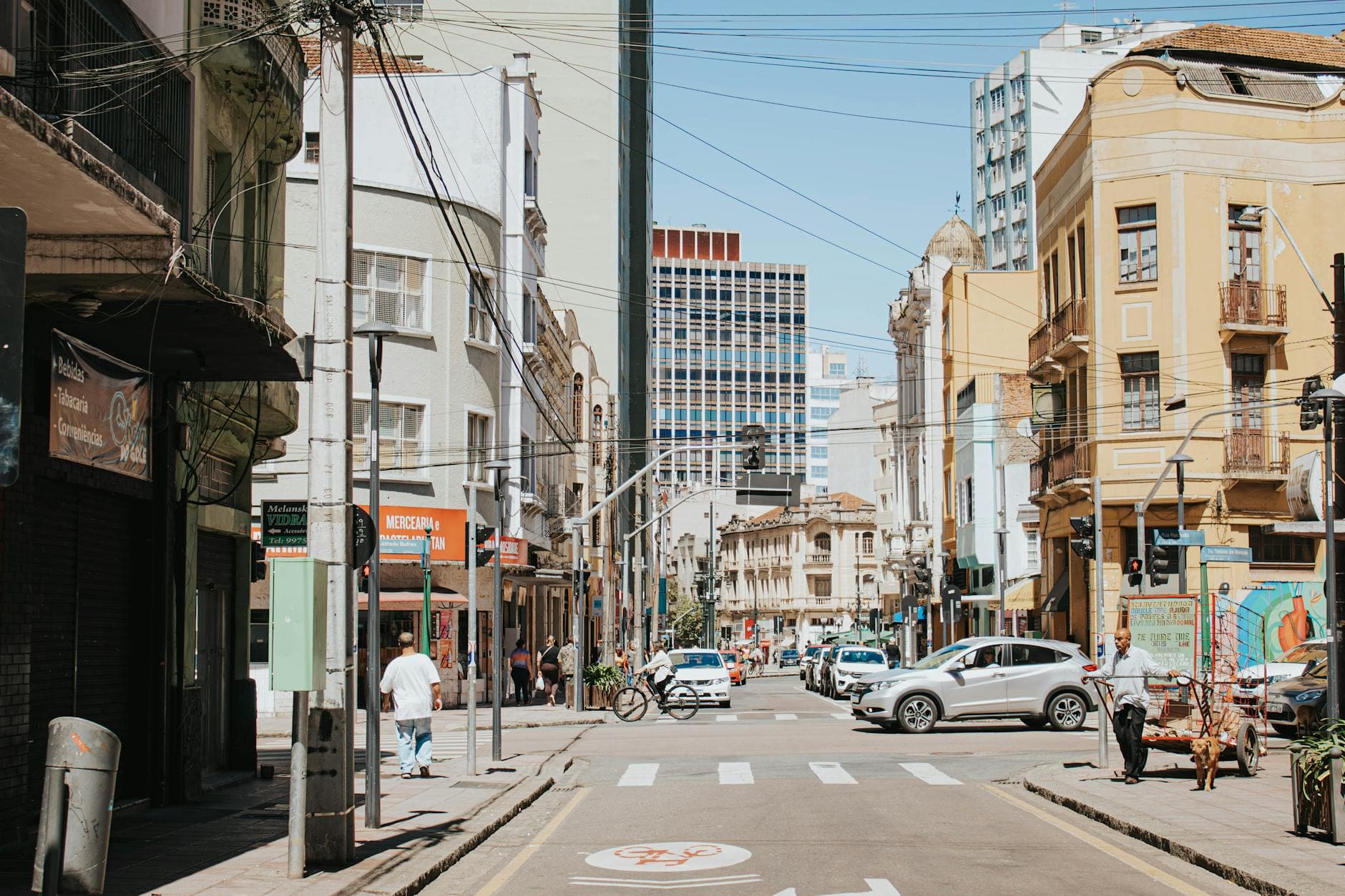 Lively intersection in Curitiba's cityscape with vehicles and pedestrians.
