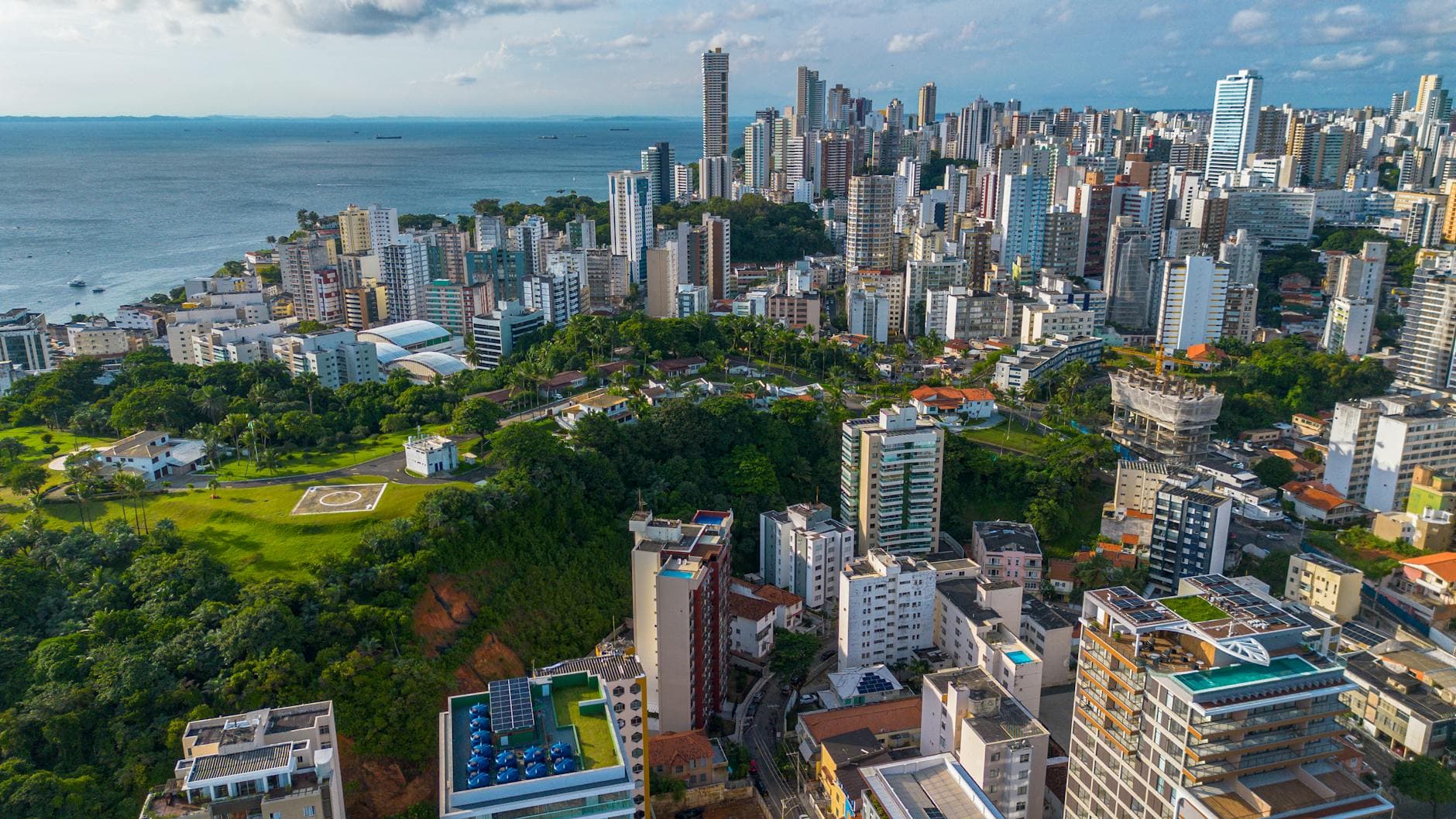 A stunning aerial view of Salvador, Brazil's modern skyline along the coast with lush greenery.