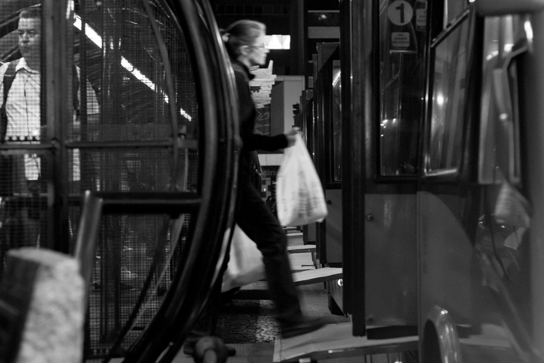 A blurred snapshot of commuters in motion at Curitiba's metro station in black and white.
