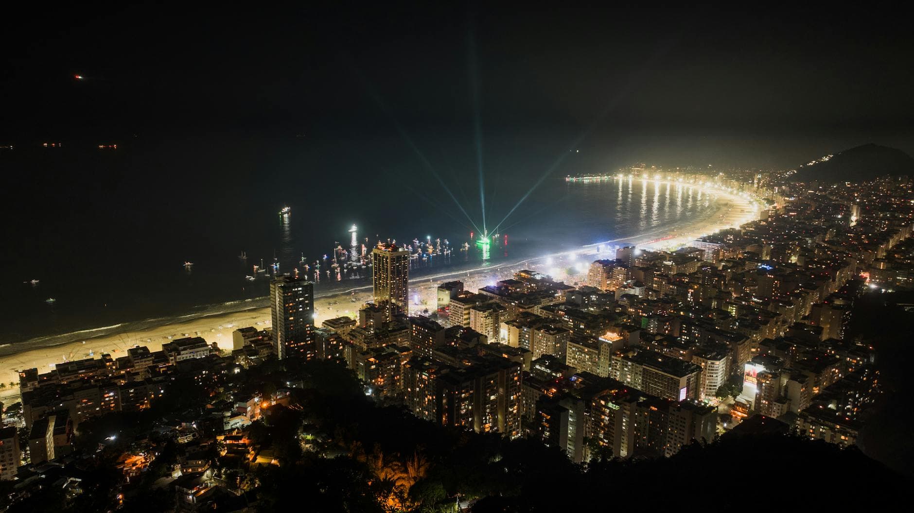 Stunning aerial view of Rio de Janeiro's illuminated coastline at night, showcasing the vibrant cityscape.