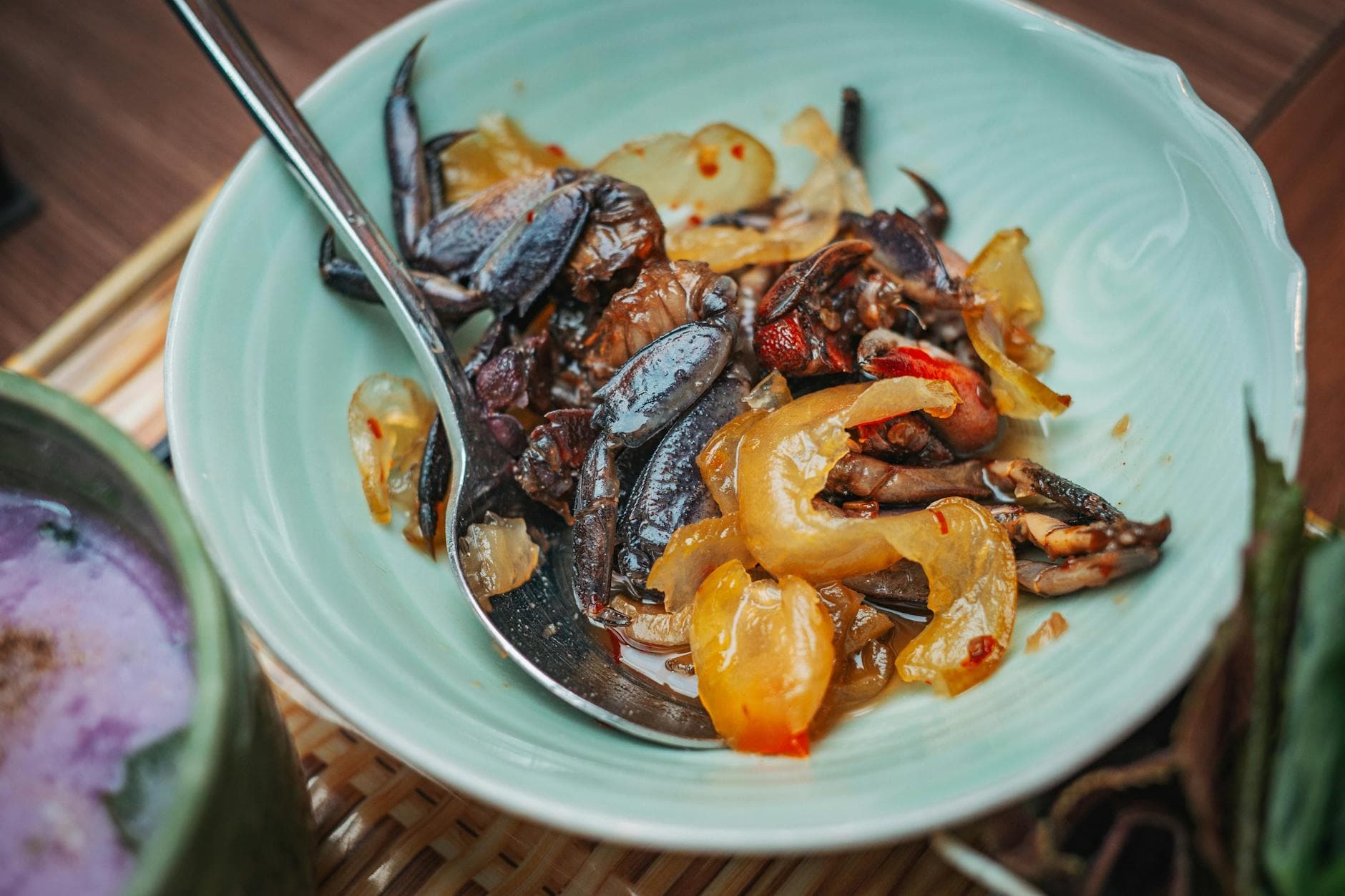 Close-up of a flavorful dish featuring stir-fried crabs with peppers served in a pastel bowl.
