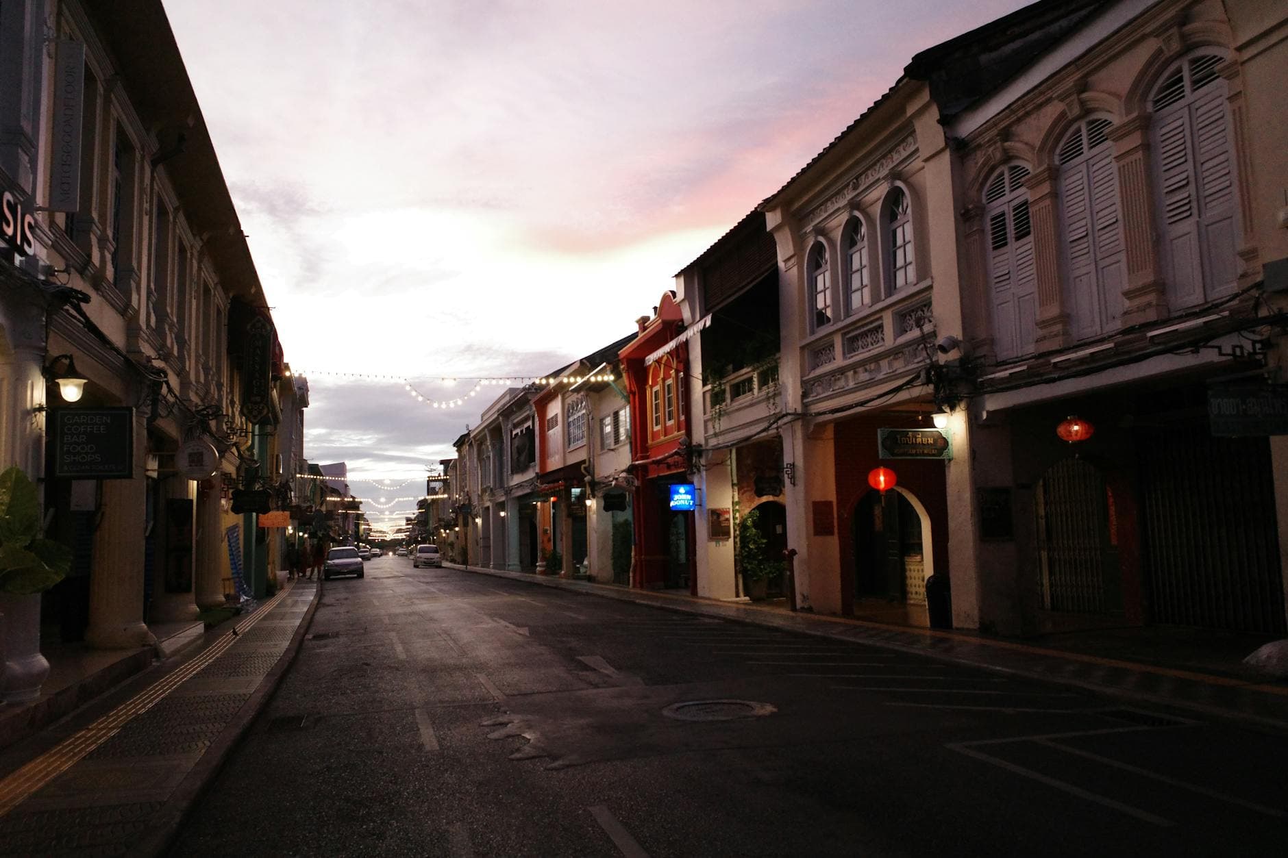 Charming colonial street in Phuket Town at dusk with vibrant architecture and atmospheric lighting.