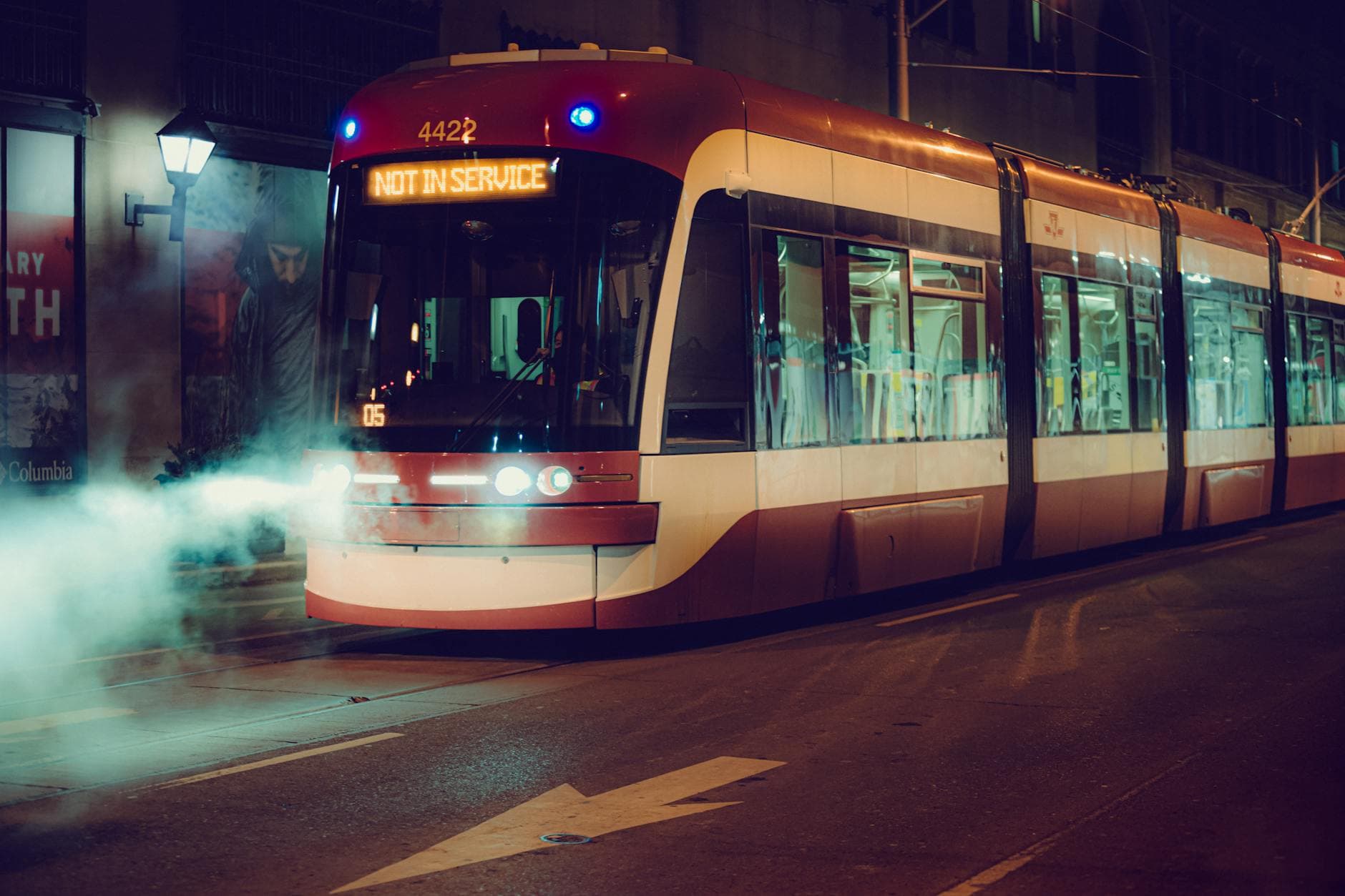 A Toronto streetcar at night, not in service, emitting steam in downtown.