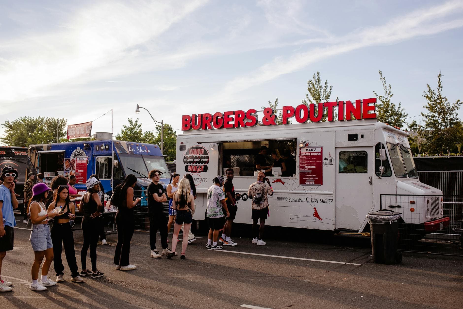 People enjoying food from a burgers and poutine truck in Toronto's urban setting.