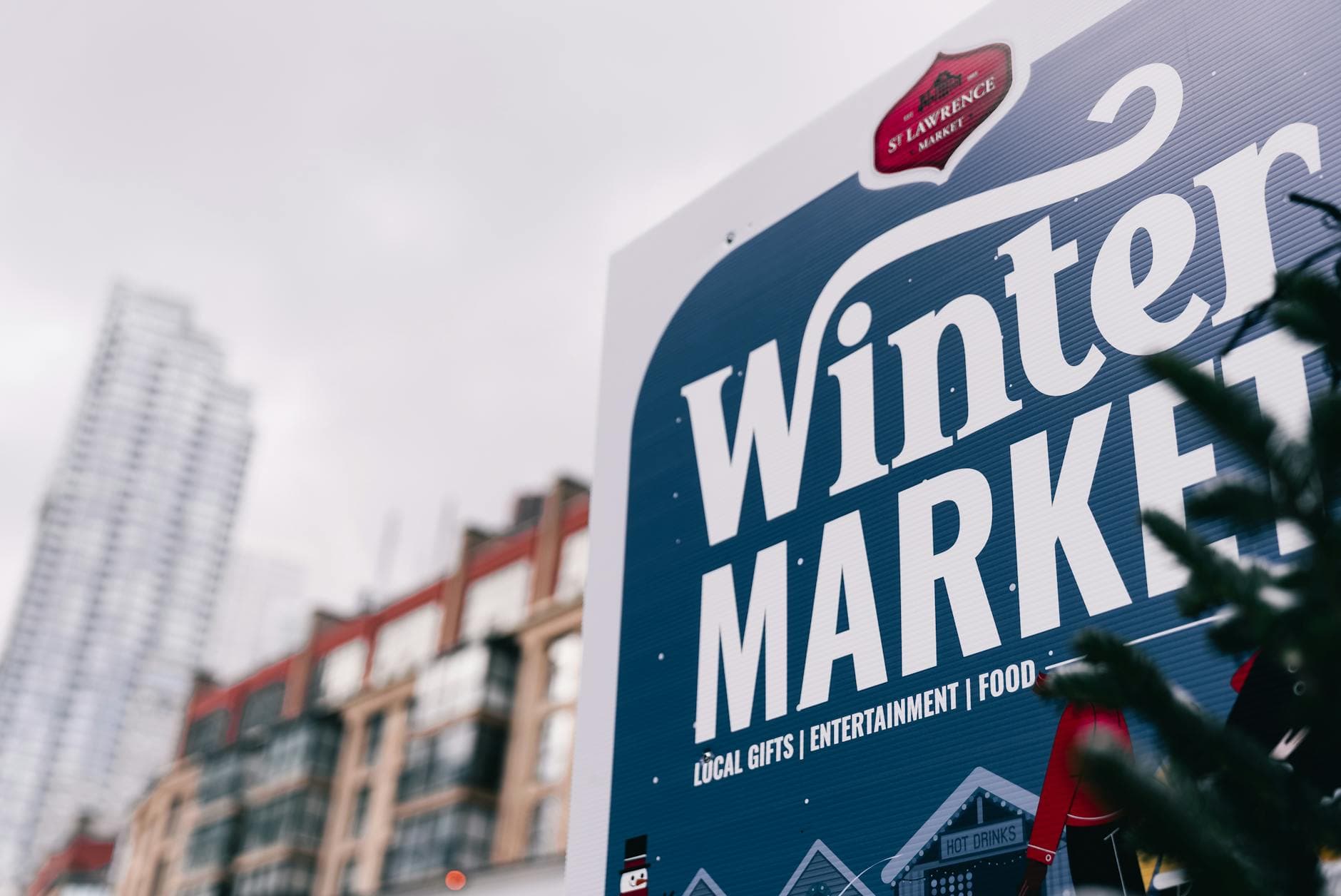 Winter Market sign at St. Lawrence with cityscape in the background, creating a festive urban atmosphere.