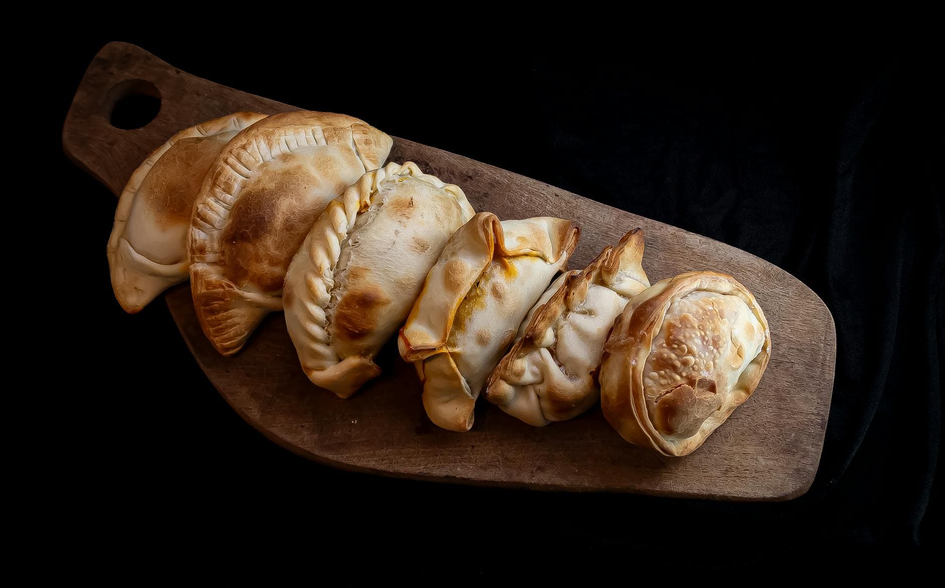 Delicious homemade empanadas on a wooden board, showcasing traditional Argentine cuisine.