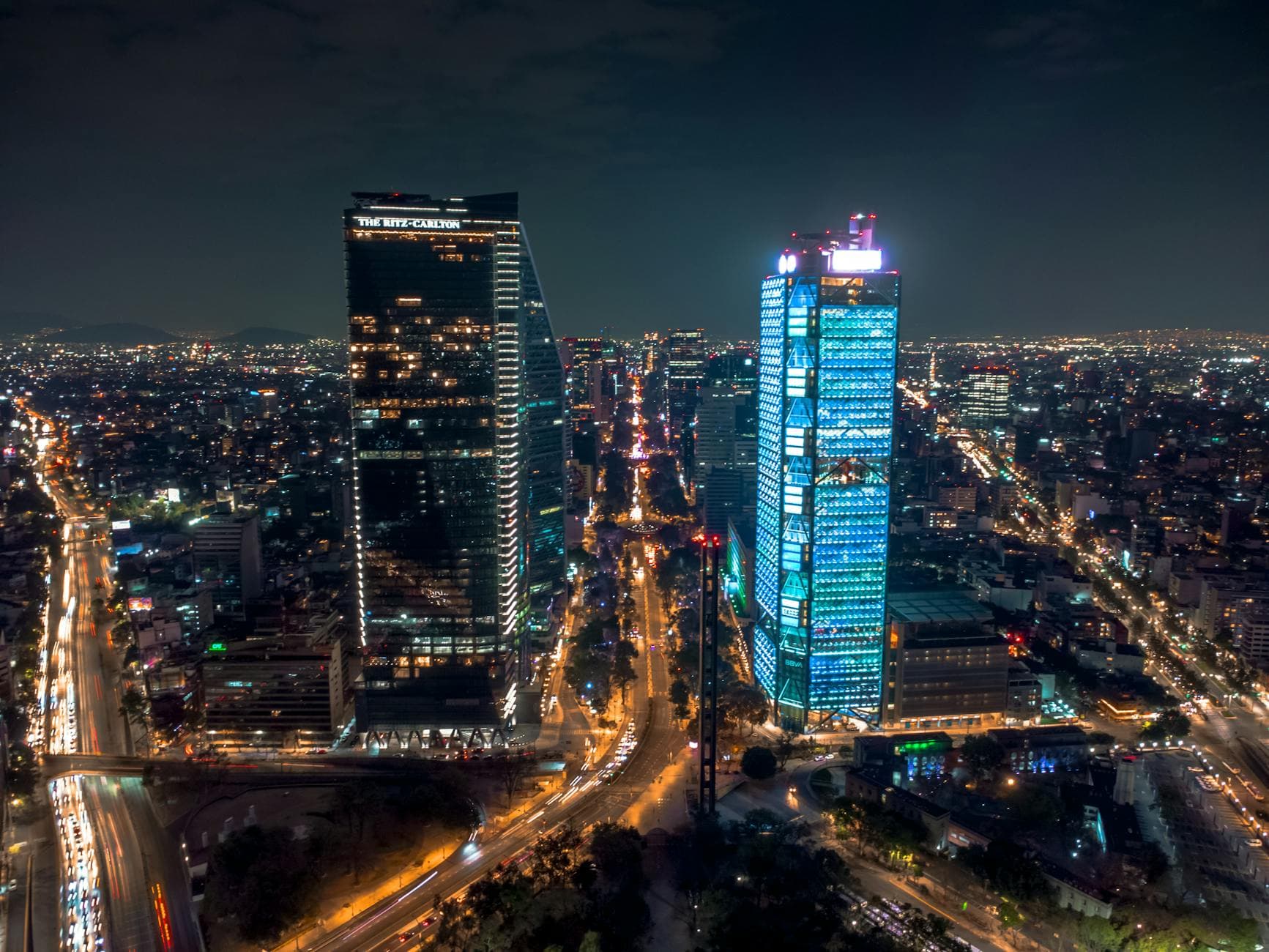 Stunning night aerial view of Mexico City's vibrant skyline with illuminated skyscrapers.