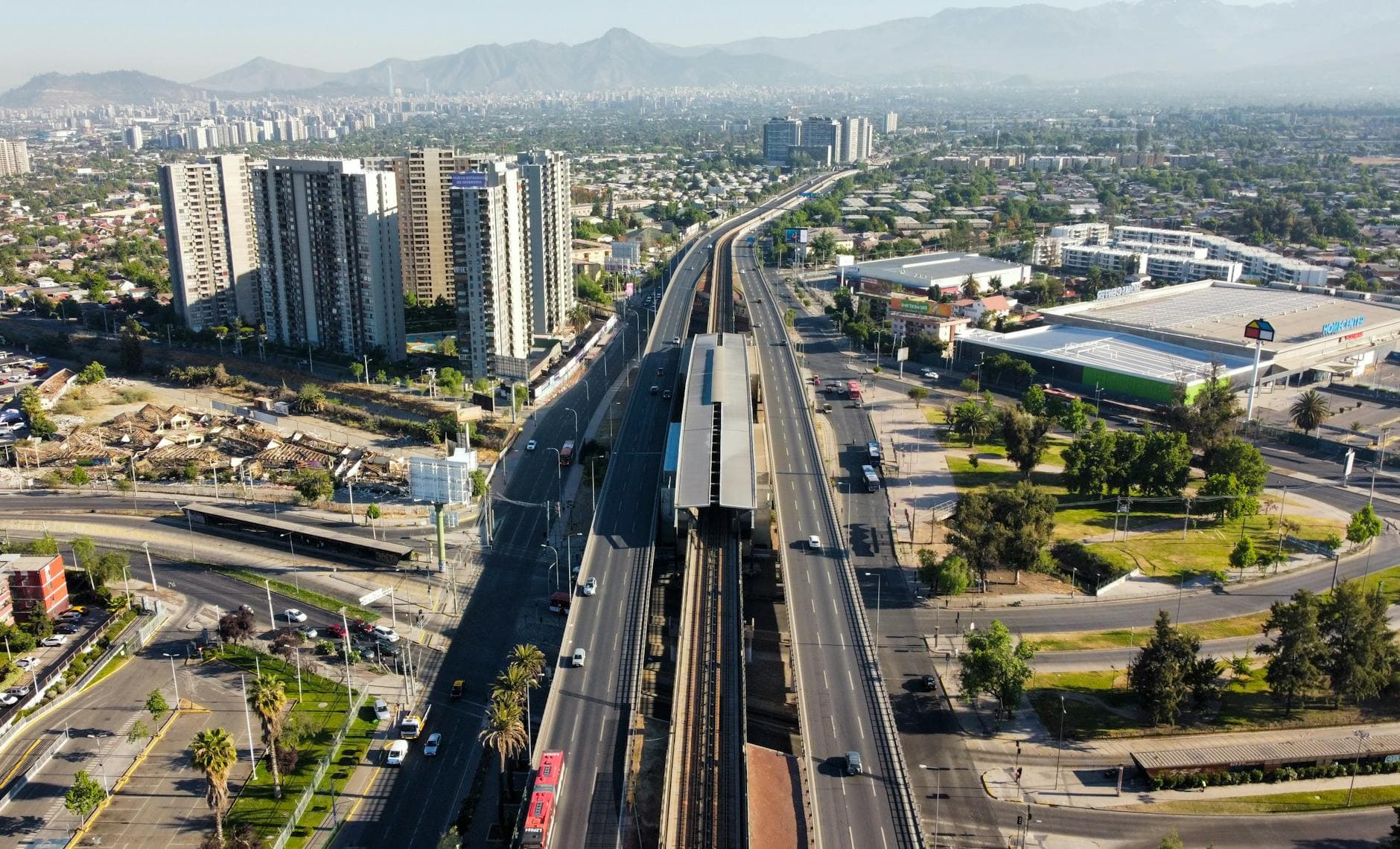 Aerial view of sprawling urban cityscape with highway and modern buildings in daylight.