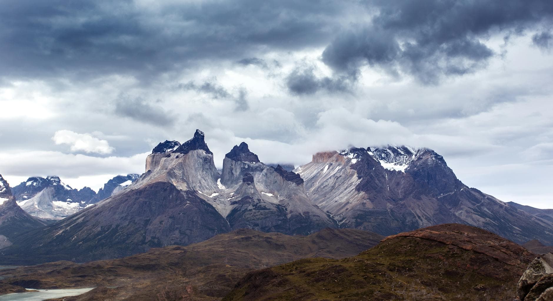 Explore the breathtaking Andes mountains in Torres del Paine, Chile, with dramatic skies and untouched nature.