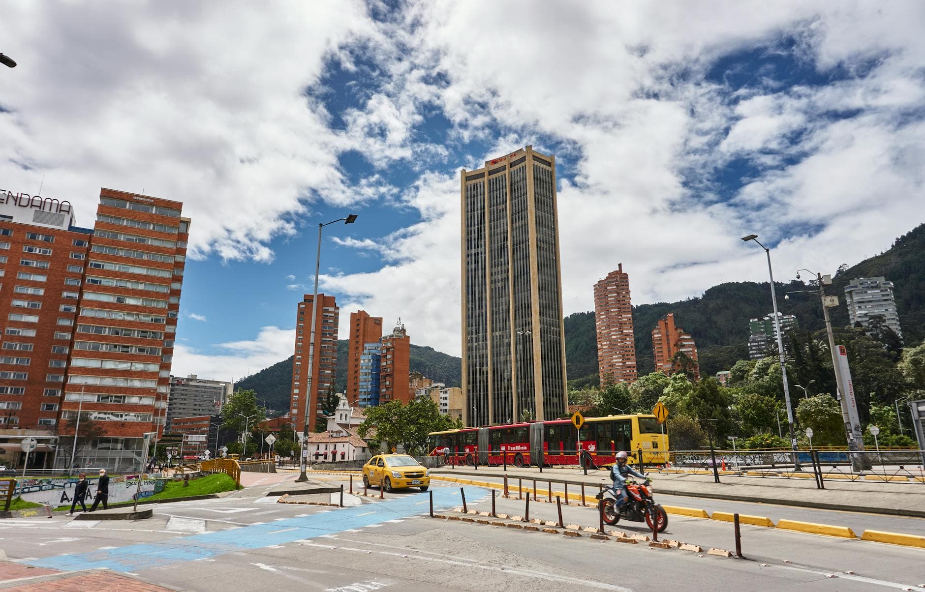 Explore the bustling streets of Bogotá, Colombia, featuring skyscrapers, TransMilenio bus, and lively urban scenery.