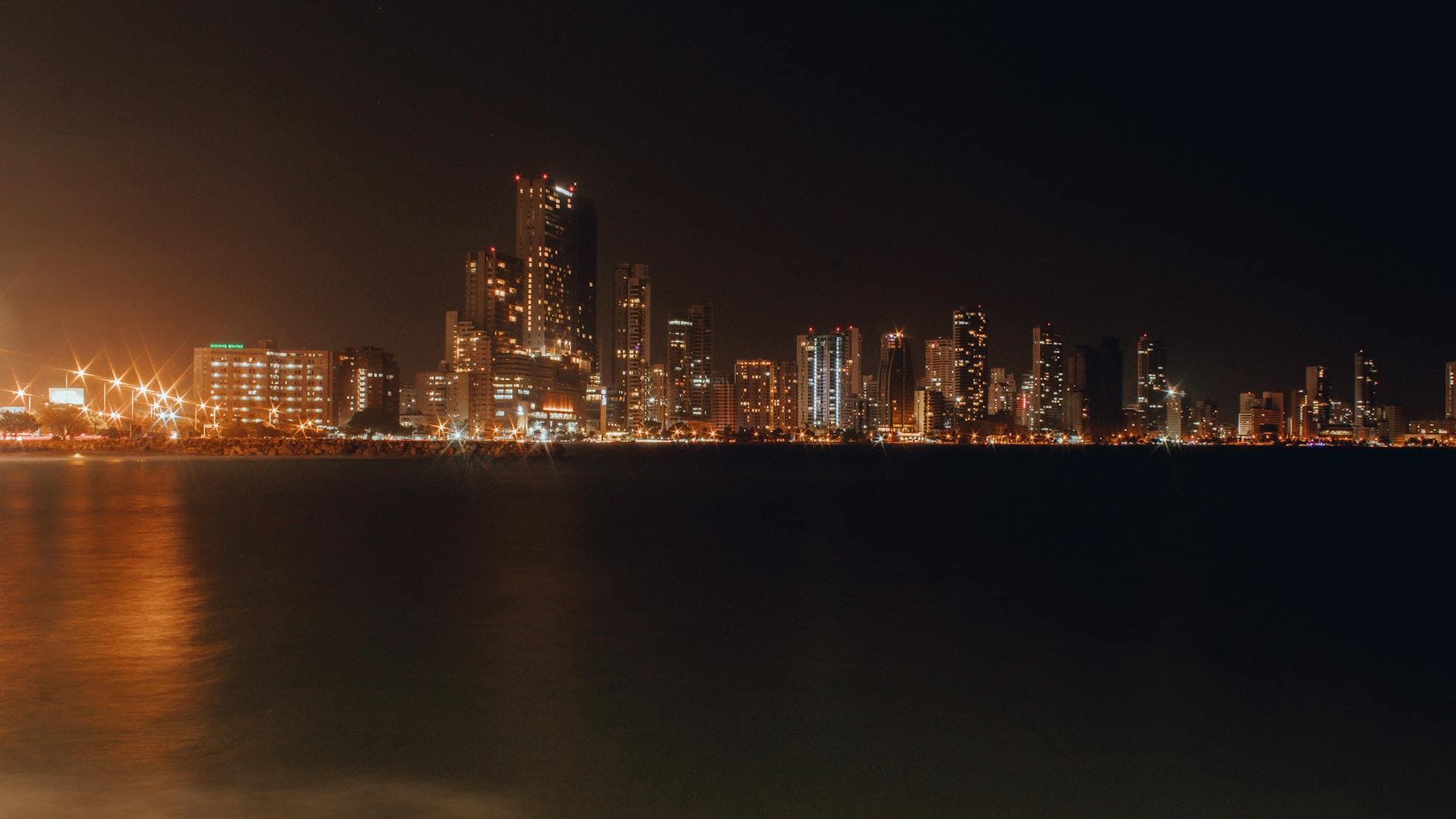 Stunning night view of Cartagena's illuminated skyline reflecting on the water.