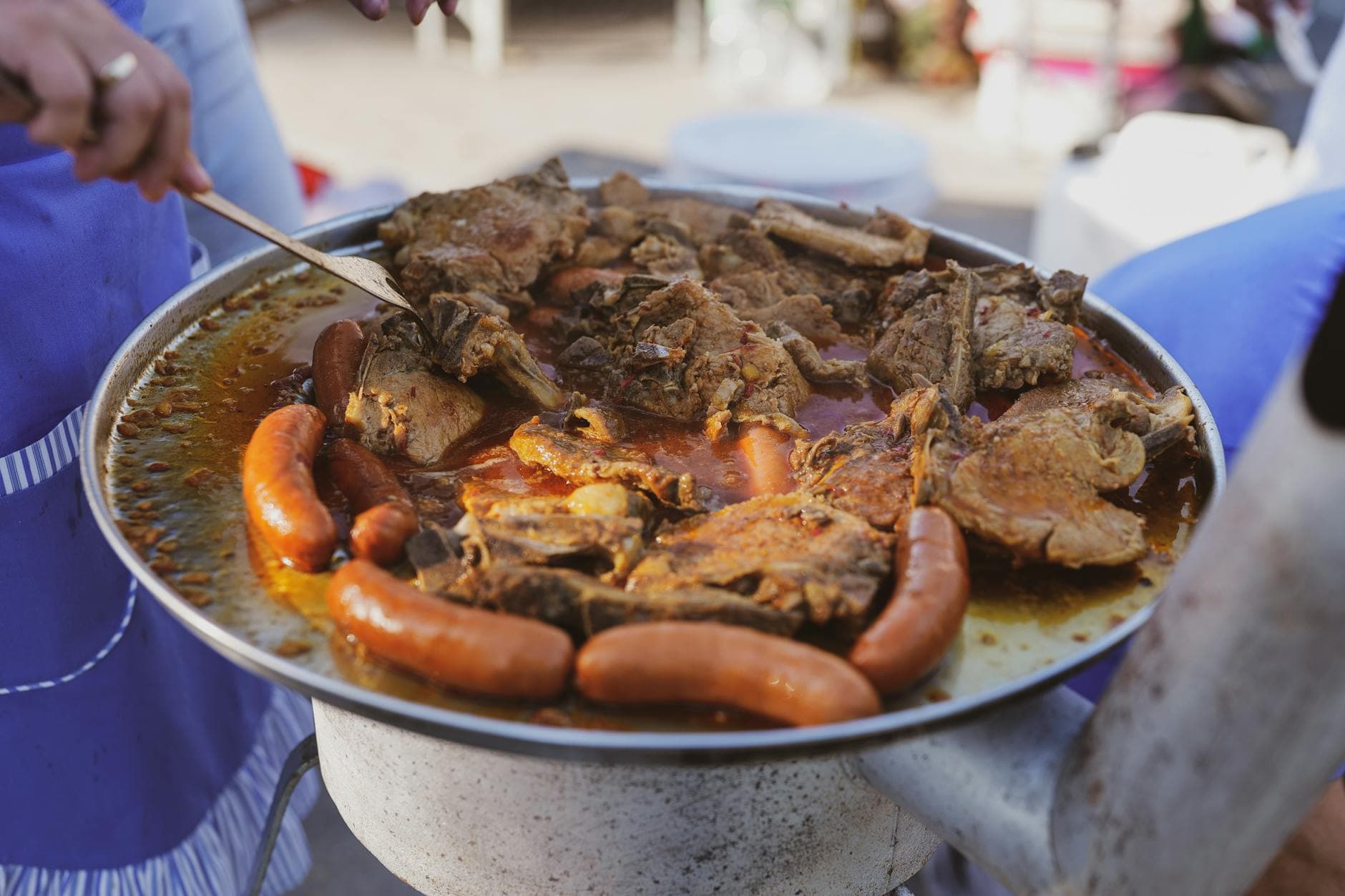 Close-up of sausages and meat grilled outdoors, juicy and sizzling.