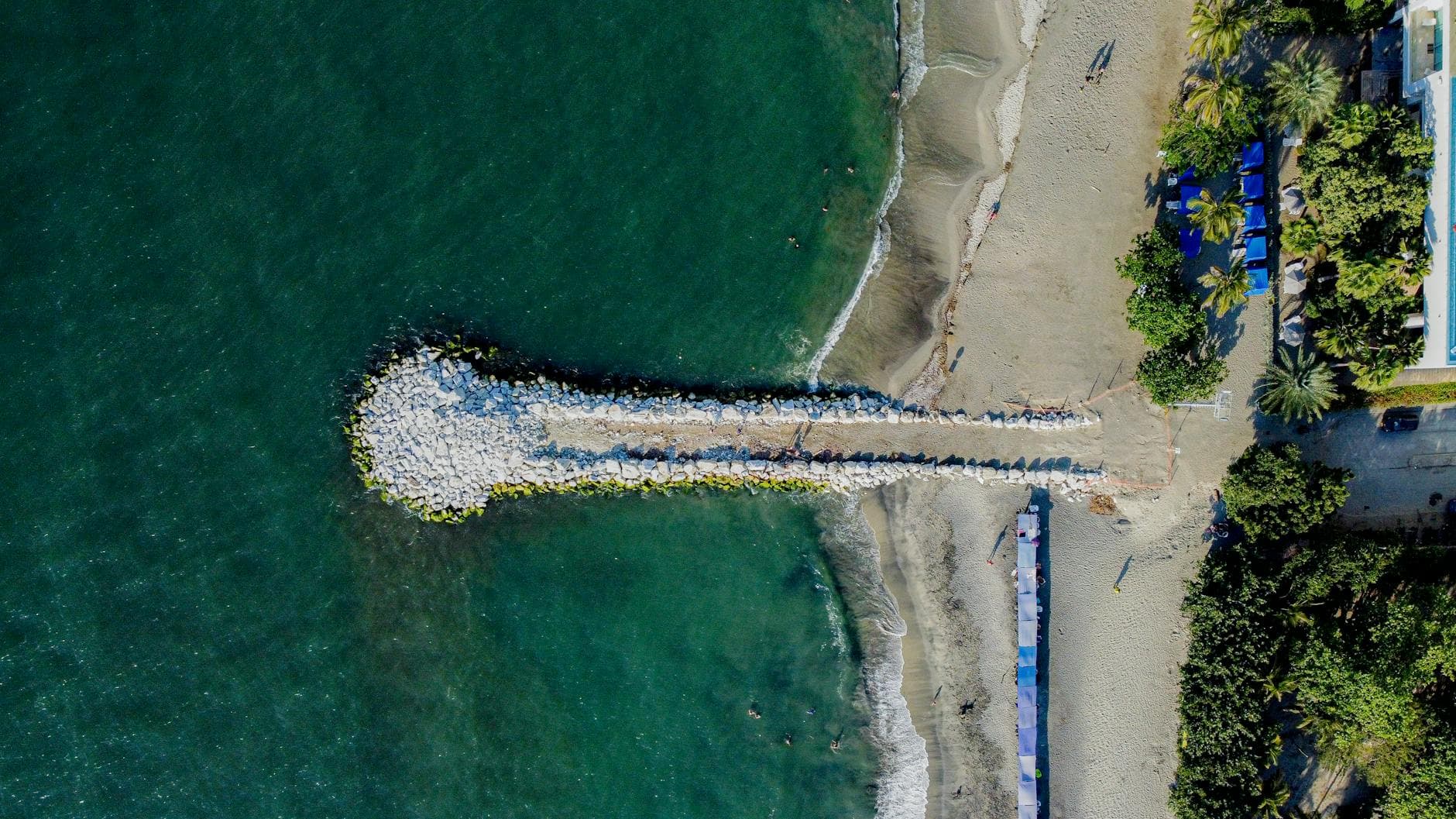 Aerial shot of Santa Marta beach, Colombia with a pier extending into the sea.
