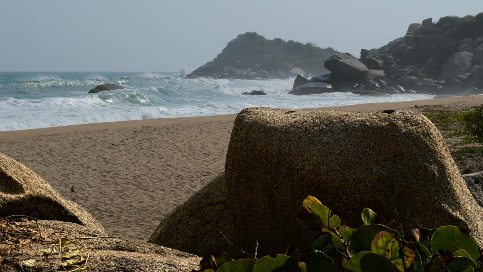 Panoramic view of Santa Marta beach with boulders and ocean waves. Perfect for nature lovers.