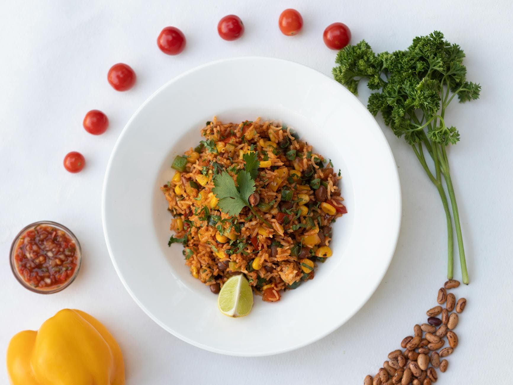 A vibrant vegetarian Mexican rice dish with fresh vegetables and spices, elegantly presented.