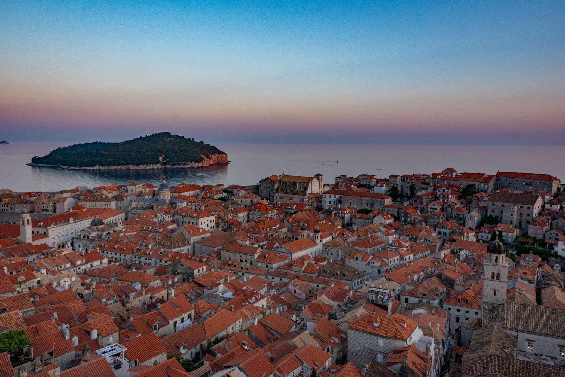 Stunning aerial view of Dubrovnik's Old Town and the Adriatic Sea at sunset.