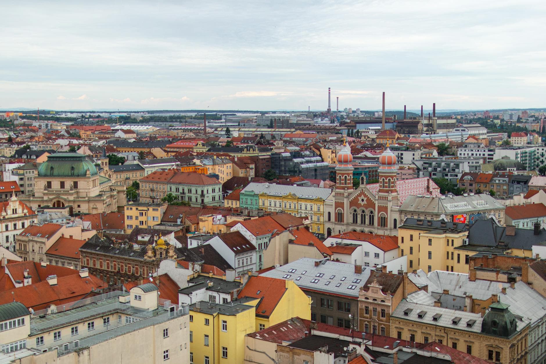 Stunning aerial view of Plzeň, showcasing vibrant architecture and city skyline under a cloudy sky.