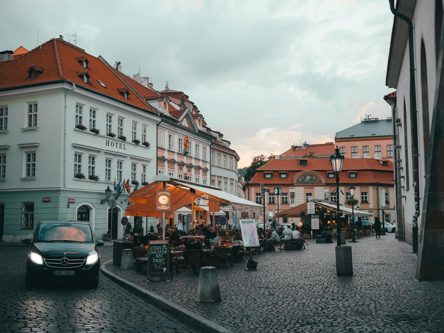 A picturesque evening view of a bustling cafe corner in Old Town Prague, Czechia.
