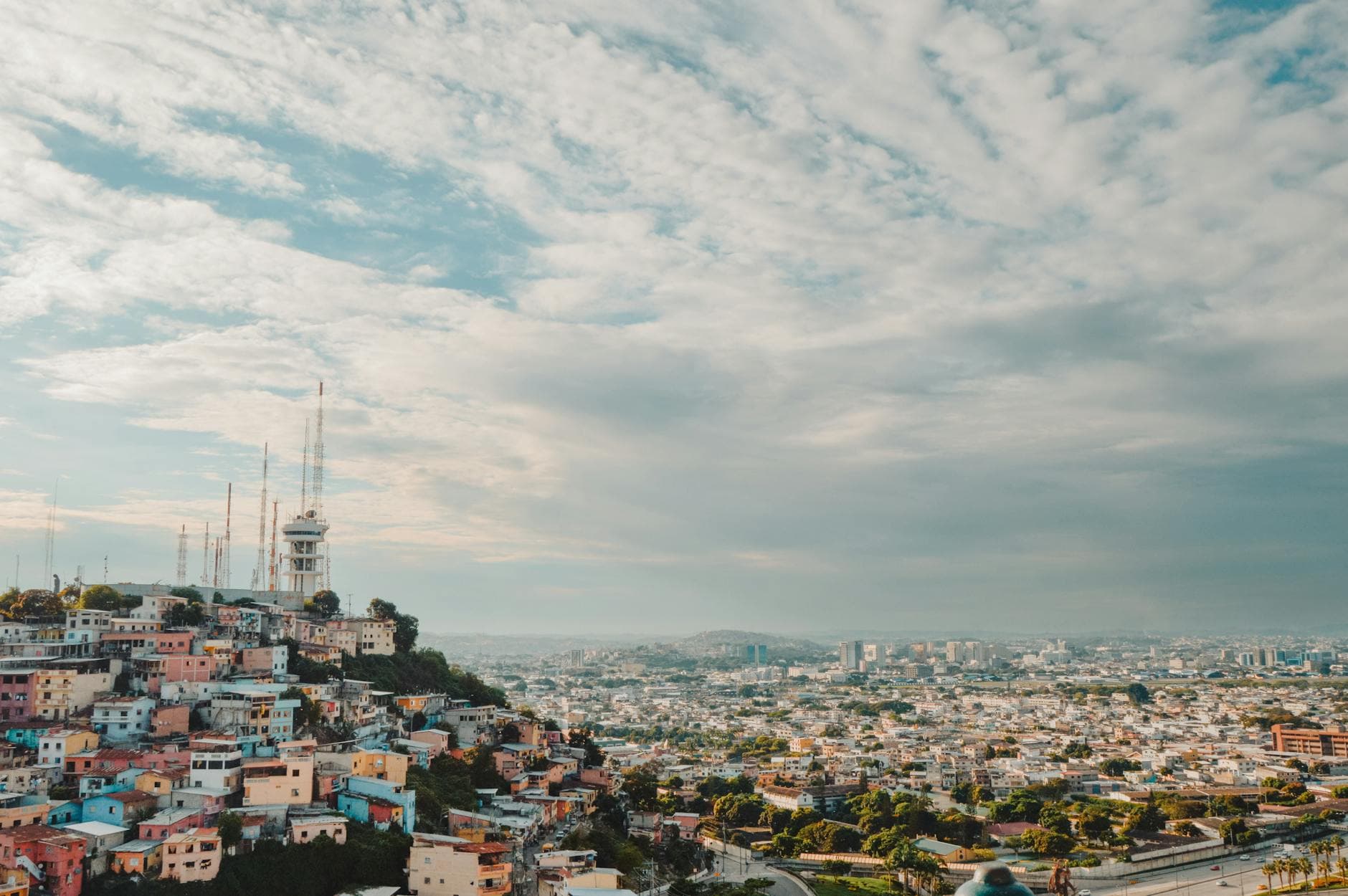 Explore the lively aerial view of Guayaquil's colorful rooftops under a clear sky.
