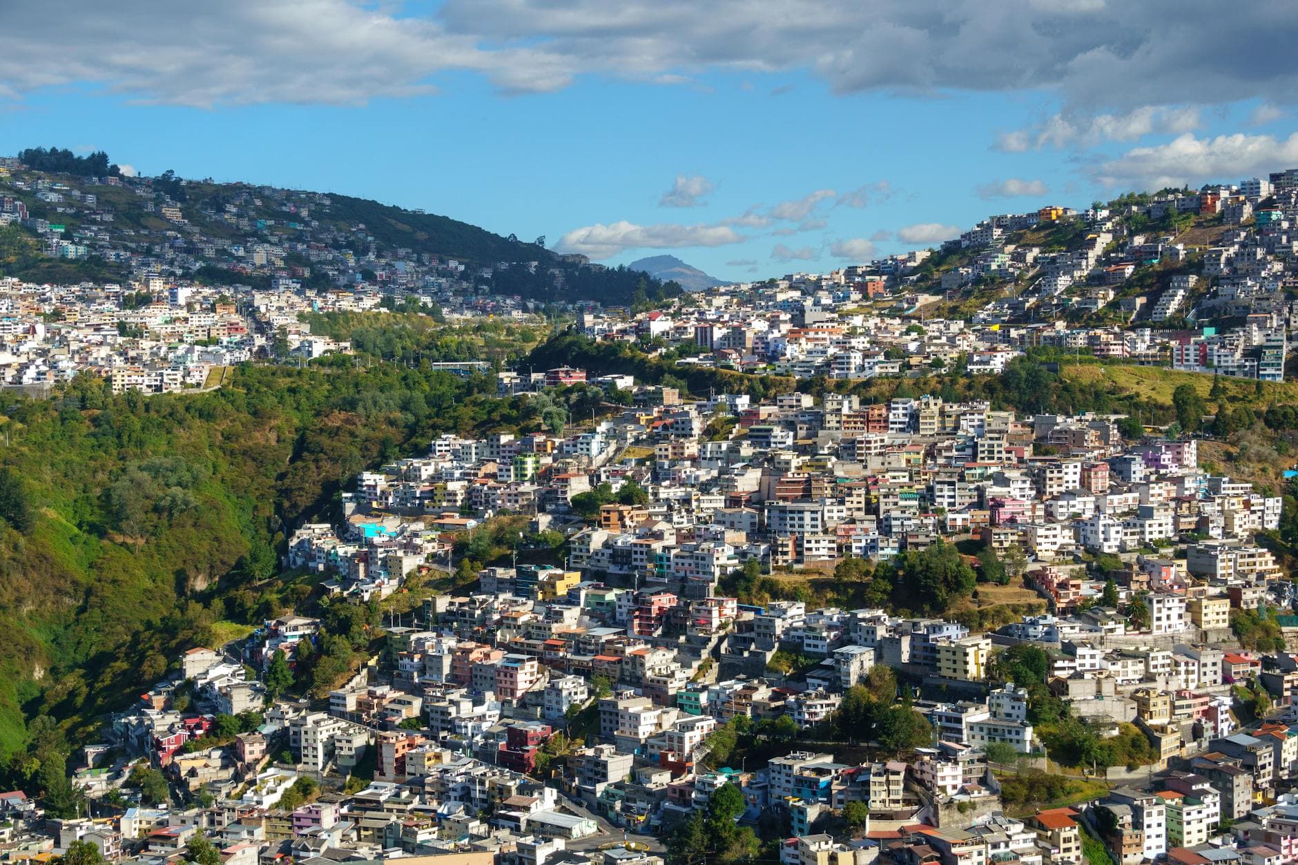 A breathtaking aerial shot of Quito's urban landscape sprawling over lush hills in Ecuador.