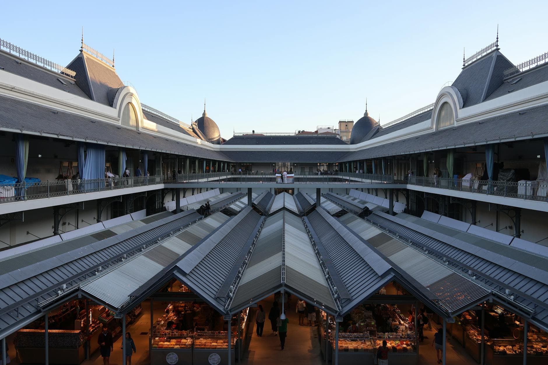 A spacious indoor market with classic architecture and high ceilings during day.