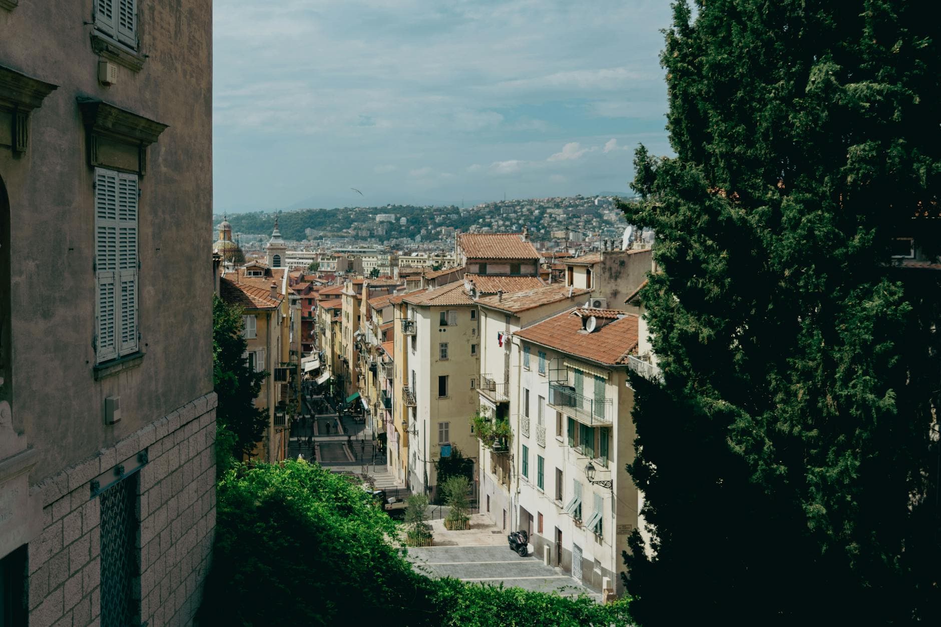 Explore the picturesque streets of Nice with historic architecture and stunning hillside views.