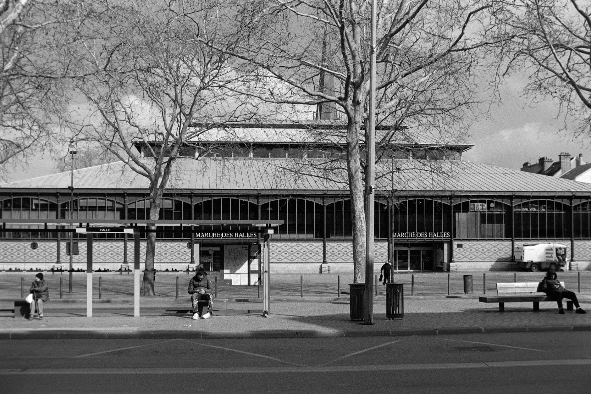 Black and white photo of Marché des Halles in Troyes, France, with people sitting and walking.