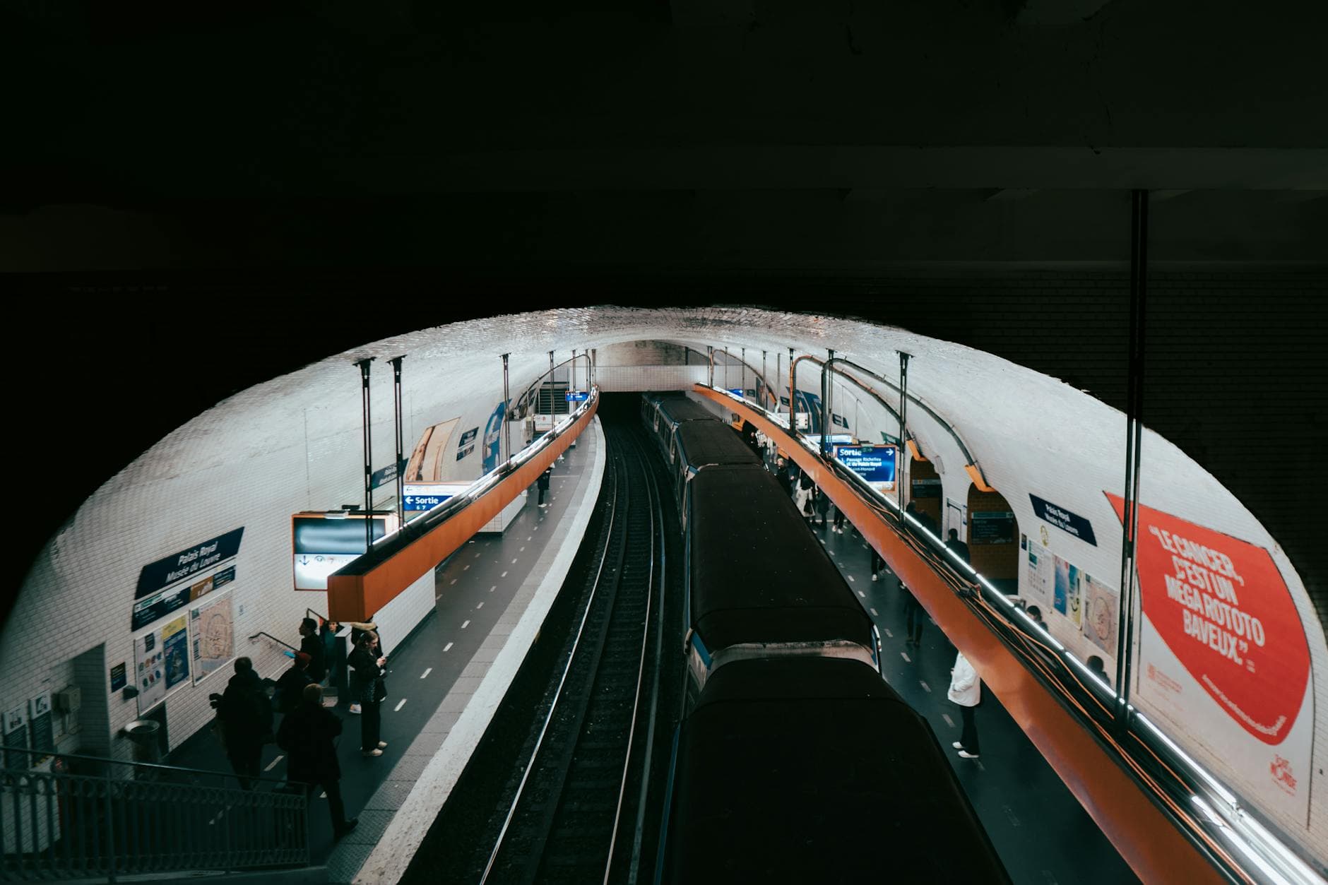 A busy Paris metro station captured with commuters waiting for their train.