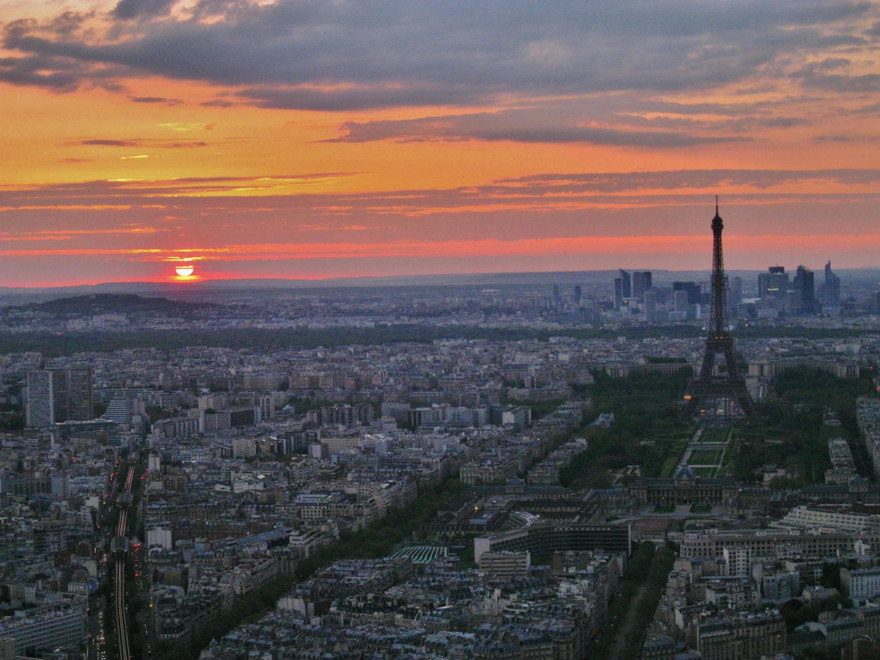 Stunning aerial view of Paris with the Eiffel Tower at sunset, showcasing the city's iconic skyline.