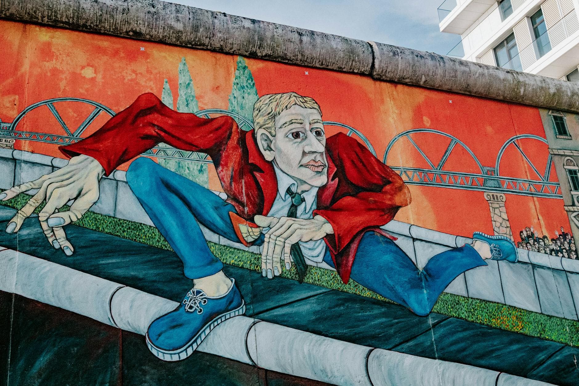 Colorful mural of a man in a red jacket on a city wall.