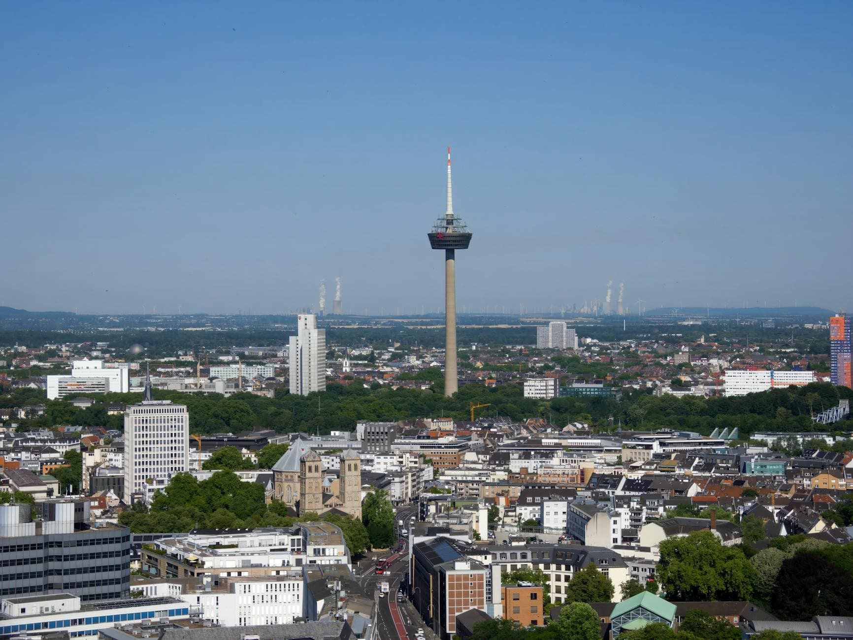 Stunning aerial view of Cologne featuring the iconic Colonius TV Tower under a clear blue sky.