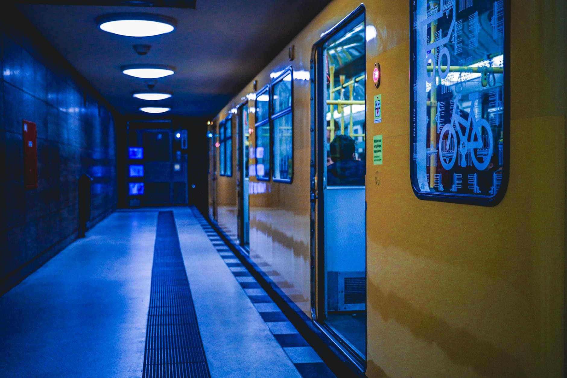 A yellow train at a Berlin subway station, illuminated at night, showcasing metro life.