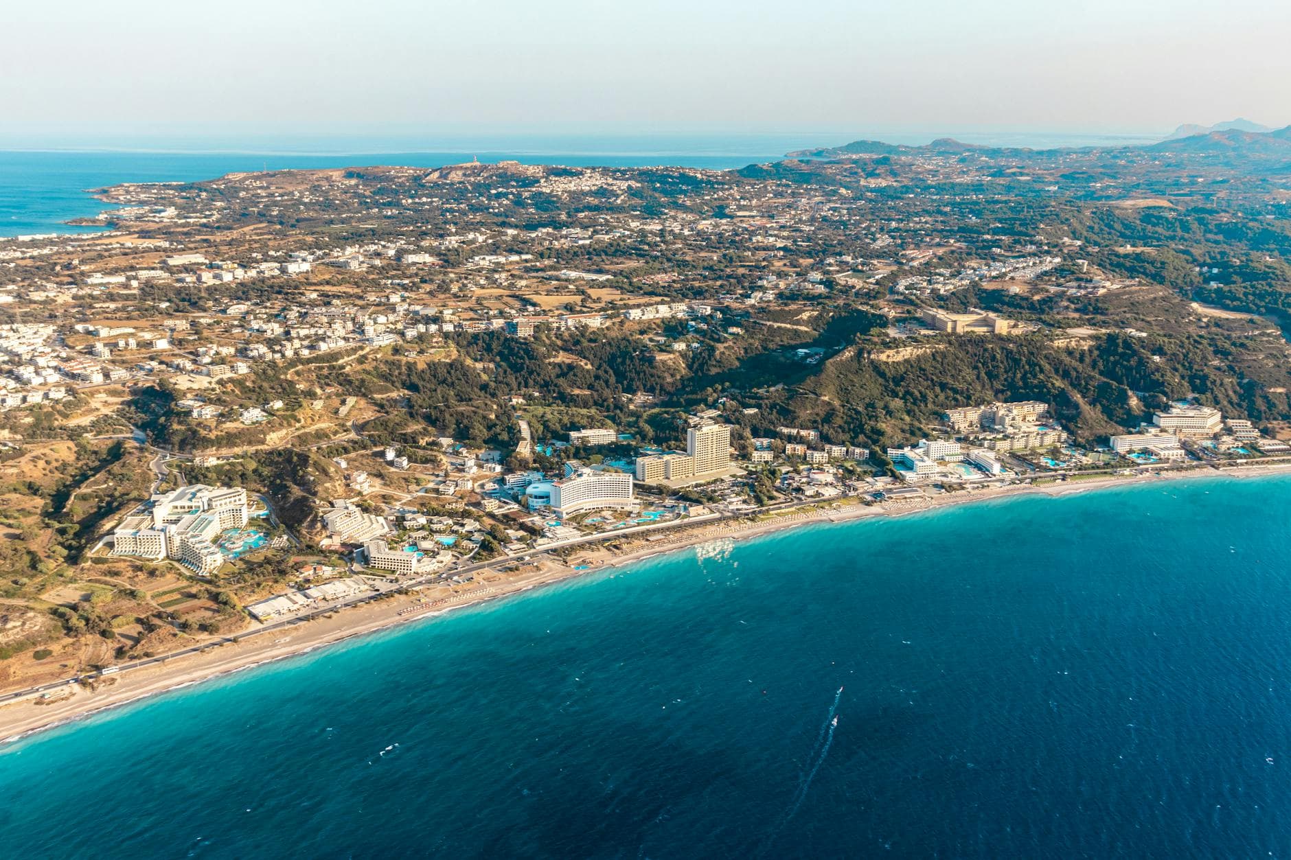 Breathtaking aerial shot of a coastal city in Rhodes, Greece, featuring stunning beaches and blue seas.