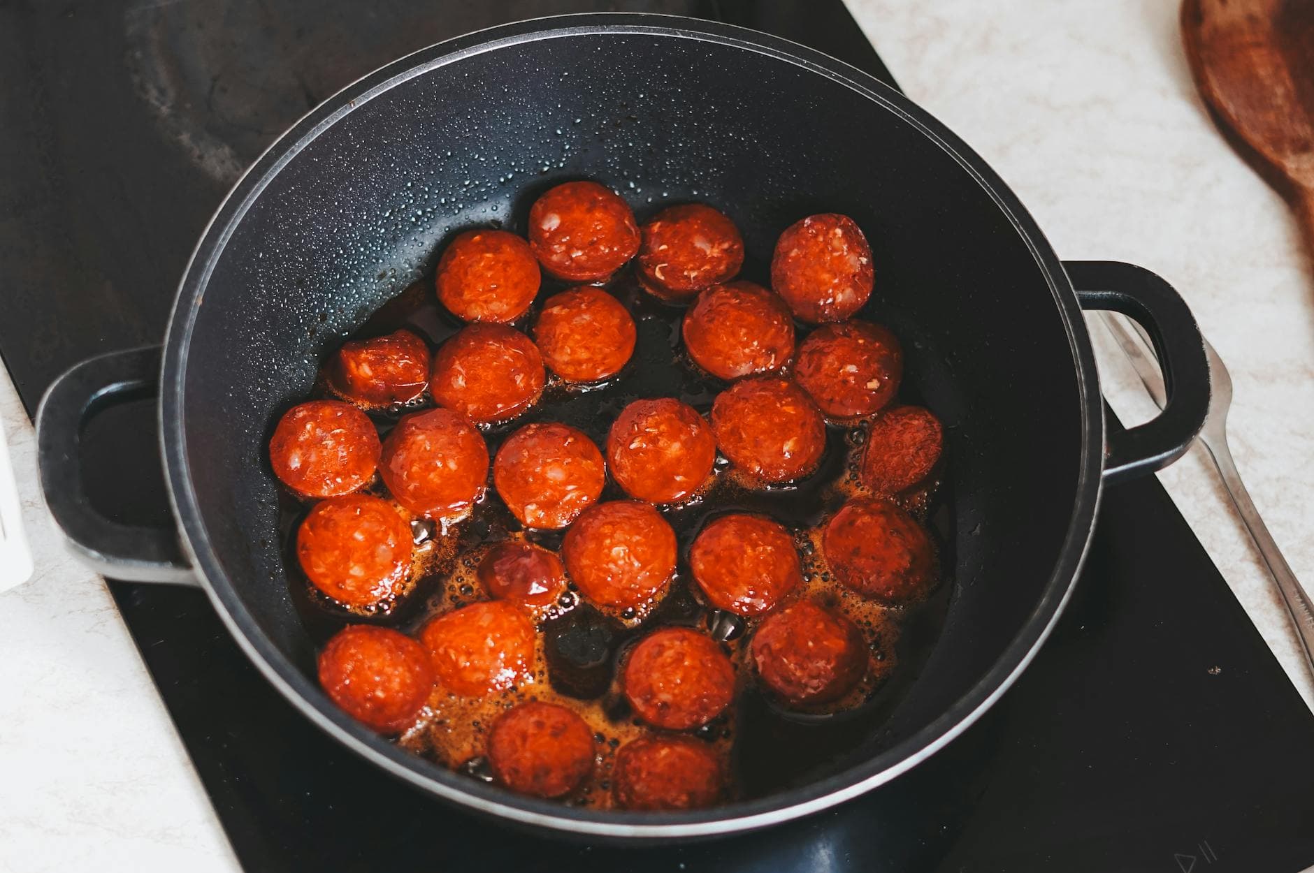 Delicious slices of Hungarian sausages frying in a pan, perfect for a hearty lunch.