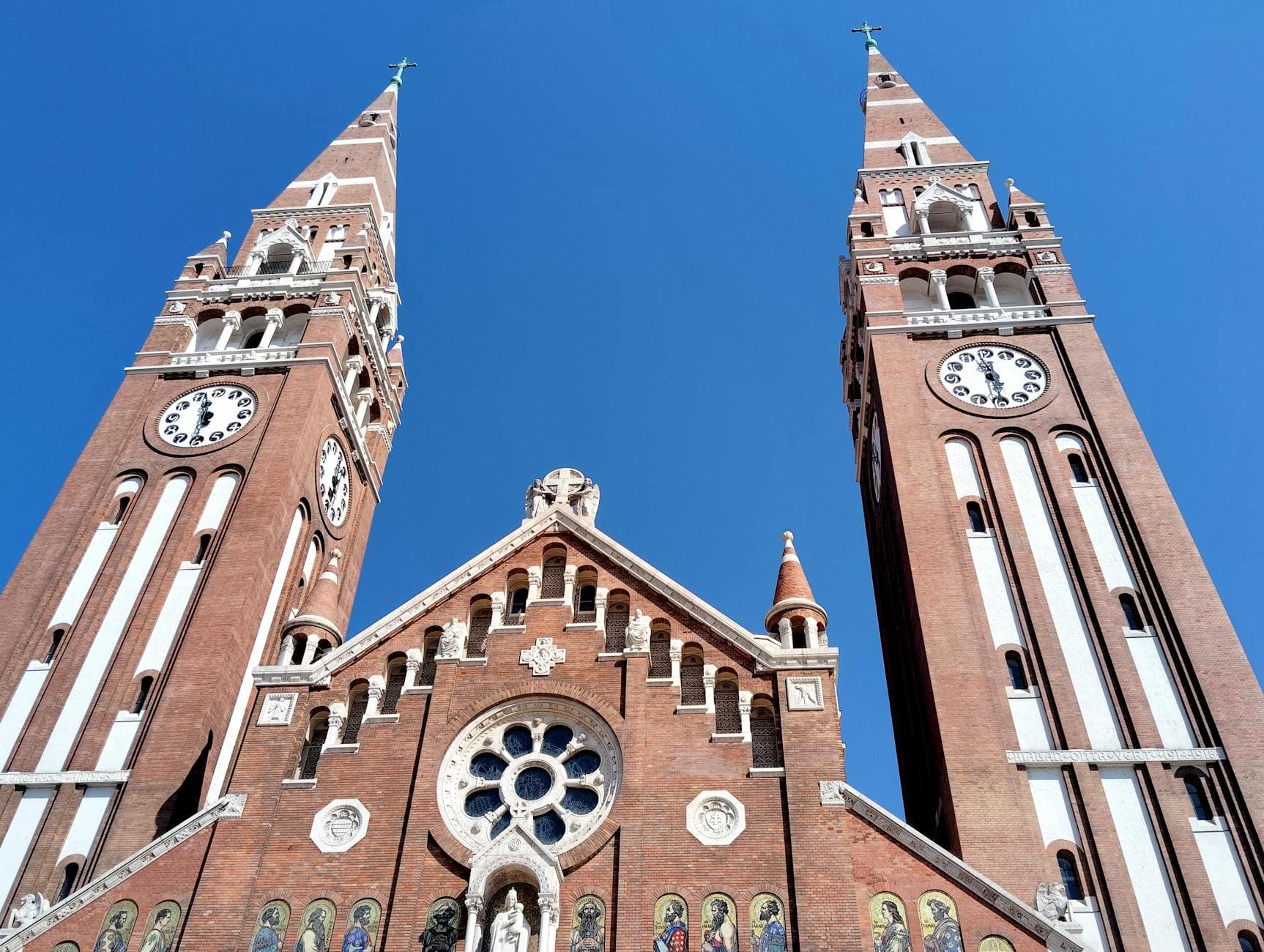 Stunning view of Szeged's Votive Church against a clear blue sky, showcasing its ornate architecture.