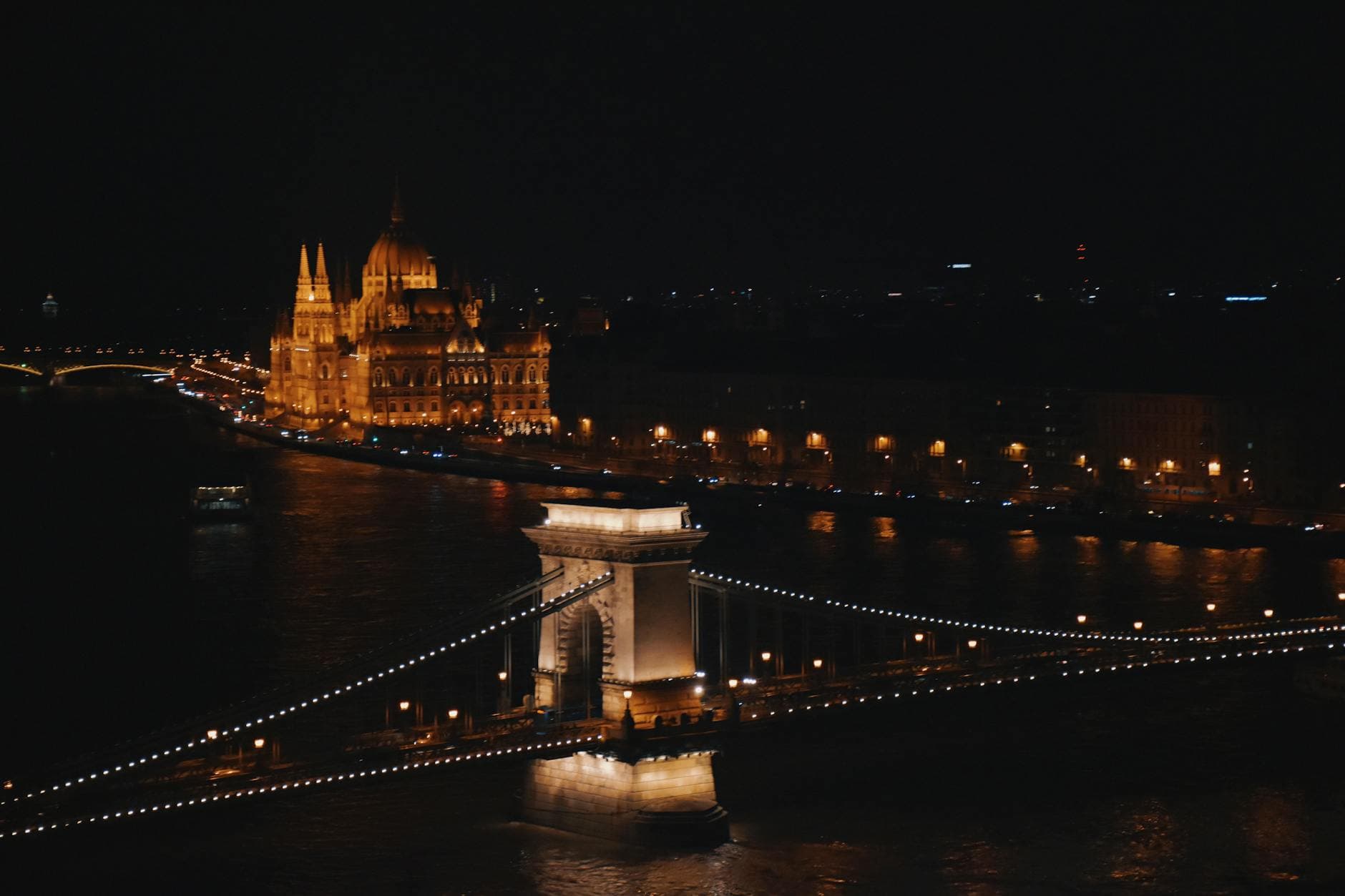 Stunning nighttime view of Budapest's Chain Bridge and Hungarian Parliament illuminated.