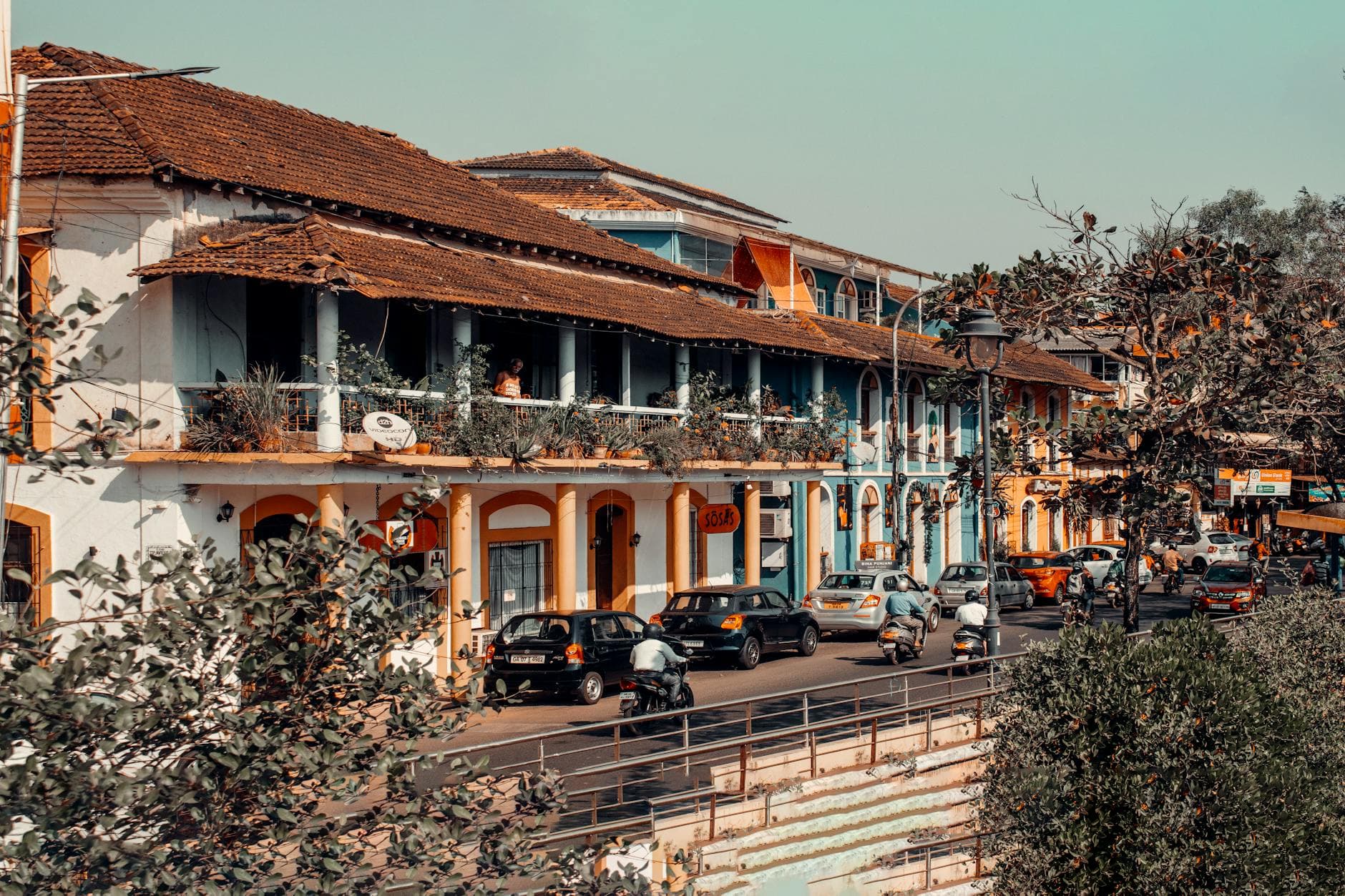 Vibrant street view in Panaji, India showcasing colorful colonial architecture and bustling traffic.