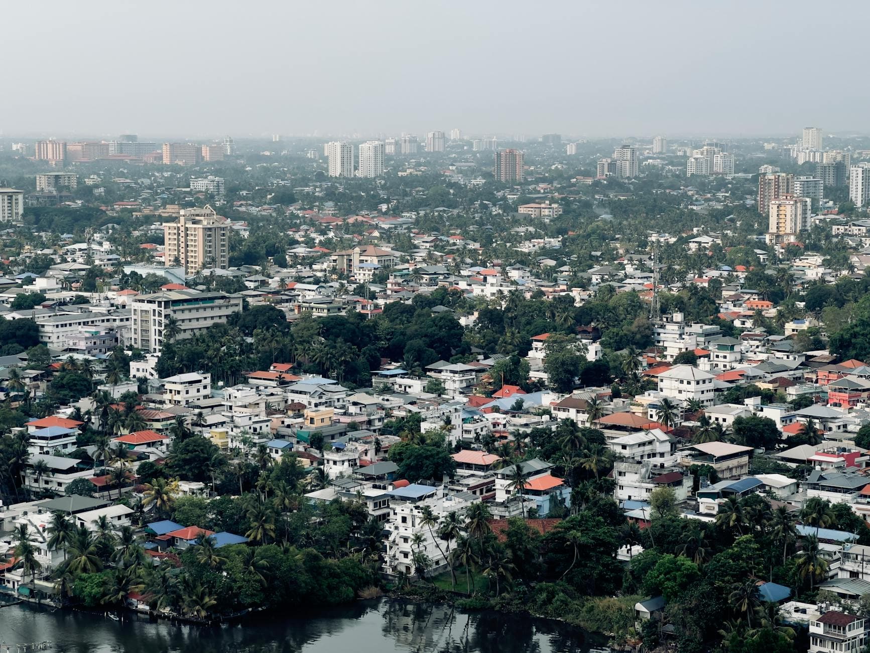Aerial view of a lush urban cityscape with high-rise buildings and dense housing.