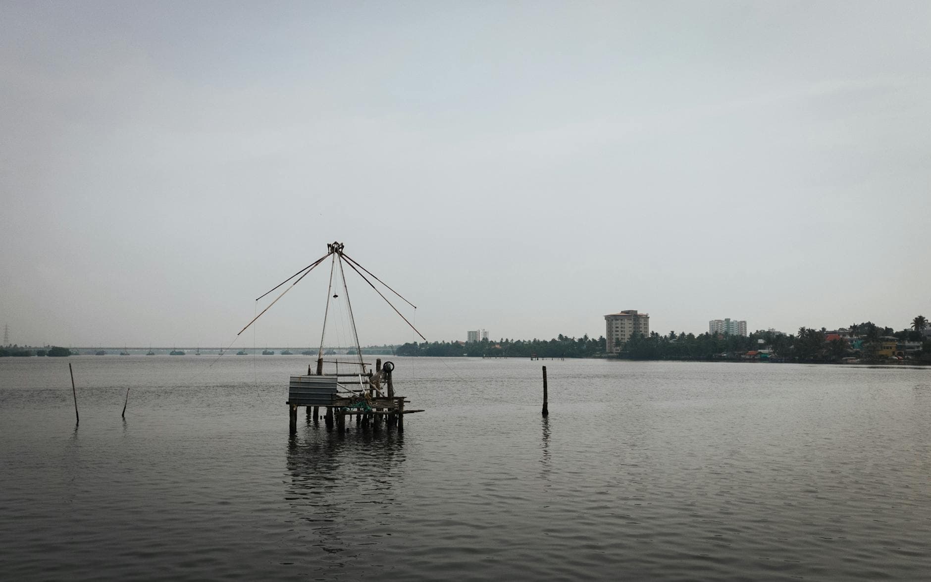 A serene view of a traditional fishing net on the coastline of Kochi, India.