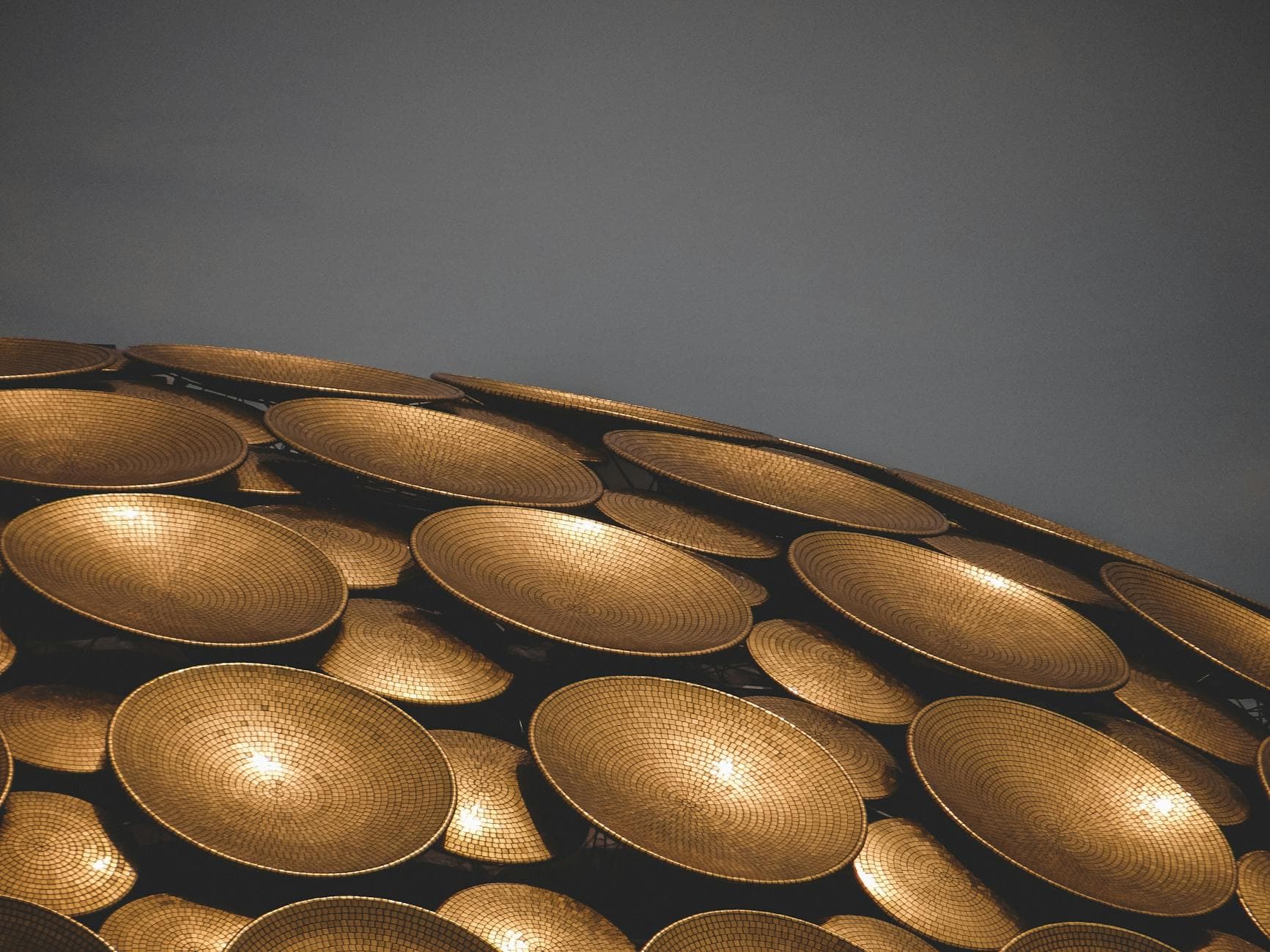 Close-up of golden discs on architectural structure in Auroville, India, with copy space.
