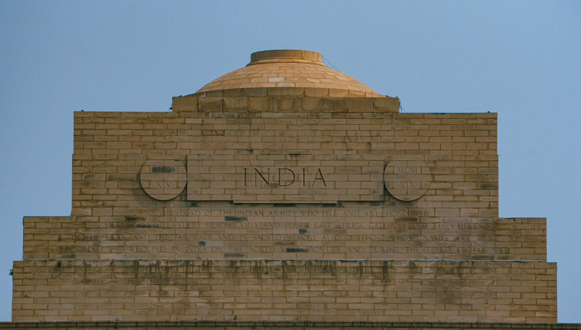 Close-up of India Gate's intricate inscriptions and architecture in New Delhi, India.