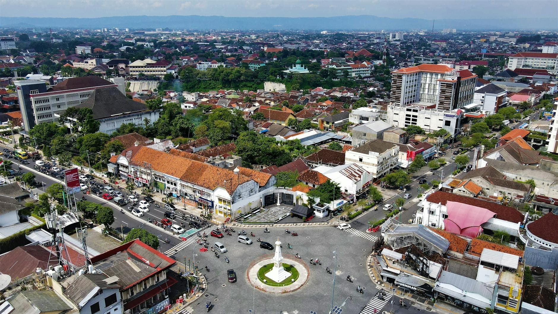 Explore an aerial cityscape of Yogyakarta, featuring the iconic Yogyakarta Monument and bustling urban streets.
